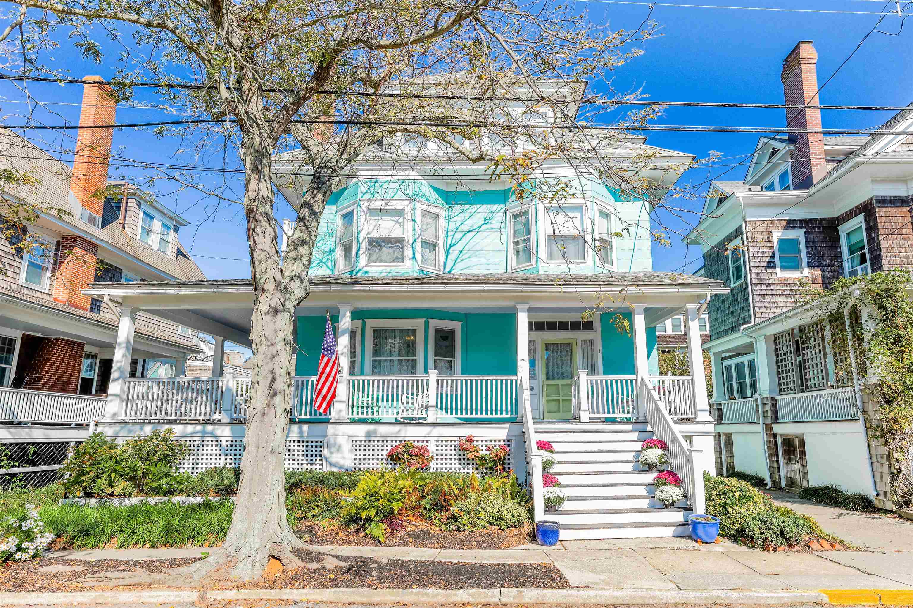 Introducing a spectacular Cape May gem nestled just one block away from the pristine Queen Street Beach, this three-story coastal retreat on Stockton Avenue is the epitome of grandeur and flexibility. Boasting a total of 8 bedrooms, 3.5 baths, and a convenient one-car detached garage, this historic beauty, built in 1905, beckons with its timeless charm and impressive features. This property is currently operated as a duplex. As you approach, you'll be captivated by the allure of the expansive wrap-around porch, a perfect spot to enjoy the sea breeze or watch the world go by. Stepping inside, the first floor welcomes you with a stately living room featuring a cozy fireplace, an inviting dining room with ample space to comfortably seat 12, and a charming kitchen that's ideal for whipping up coastal-inspired meals. Additionally, the first floor offers a full bath, a bedroom, and a convenient half bath with an exterior entrance, making it an ideal space for accommodating guests or family members. The second floor unfolds with five additional well-appointed bedrooms, creating a haven for rest and relaxation after a day spent at the beach. A full bath on this floor ensures convenience and comfort for everyone. For even more versatility, the third floor is set up as a self-contained apartment, featuring a fully-equipped kitchen, a cozy living room, two bedrooms, and a full bath. This unique layout allows for independent living arrangements, making it perfect for multi-generational families or those seeking a rental income opportunity. This remarkable property boasts a lucrative rental history, presenting an irresistible investment prospect. You have the flexibility to either rent one unit and relish the other for personal use or capitalize on the full-house rental potential. Furthermore, this property is a candidate for conversion into a single-family residence, subject to buyer obtaining necessary approvals.  Outside, a lush and inviting backyard offers the perfect setting for barbecues or post-beach relaxation. The driveway is thoughtfully designed for other uses, with the garage serving as a secure space for bikes and more. Situated in the highly desirable Stockton Avenue neighborhood, this extraordinary property is only a short stroll away from Cape May's charming downtown area, ensuring that you're never far from the town's vibrant culture and culinary delights. And with the beach just a block away, you'll have quick and easy access to the sun, sand, and surf that Cape May is famous for.