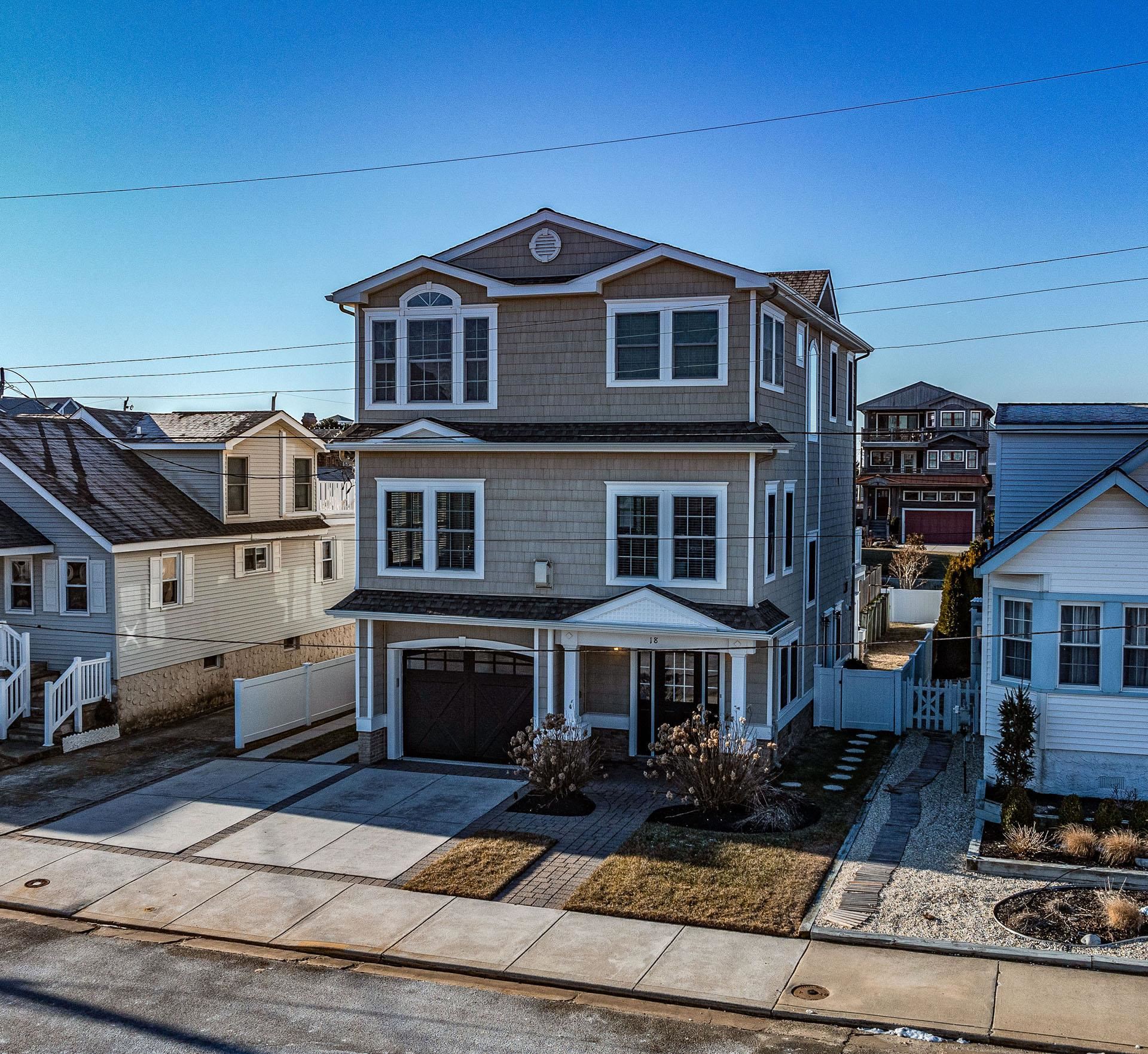 Experience seaside charm paired with casual luxury in this classic Strathmere single family beach block property.  Located in a desirable Southside of the street location 18 Vincent is the perfect blend of thoughtful design coupled with expert craftsmanship to produce a truly stunning product.  Upon entering the home on the lower level you will discover a spacious tiled foyer wrapped by tasteful wainscotting. Heading upstairs you will find yourself on the main living level featuring hardwood flooring flowing through the kitchen, living & dining spaces.  The living room features a gas fireplace flanked by built-in benches cleverly tucked under a wall of windows flooding the space with natural sunlight & cool ocean breezes.  Adjacent to the living room is the Chefs kitchen highlighted by the custom cabinetry & matching hood, oversized island, paneled appliances, wine cooler, & more.   Off the rear of the home is a warm & inviting Florida room with connected fiberglass deck offering direct Southern exposure and Ocean views.  The upper level houses three well-appointed bedrooms including the spacious primary suite marked by the hotel style bathroom with jetted tub, water closet, makeup vanity, & more.  Additional highlights include a tankless water heater, Wi-Fi climate control, professional AV system, cedar impression siding, one car attached garage with off street parking for an additional three vehicles, generous fenced in backyard & more.  Enjoy the tranquility of Strathmere from this immaculate & truly turn-key property.