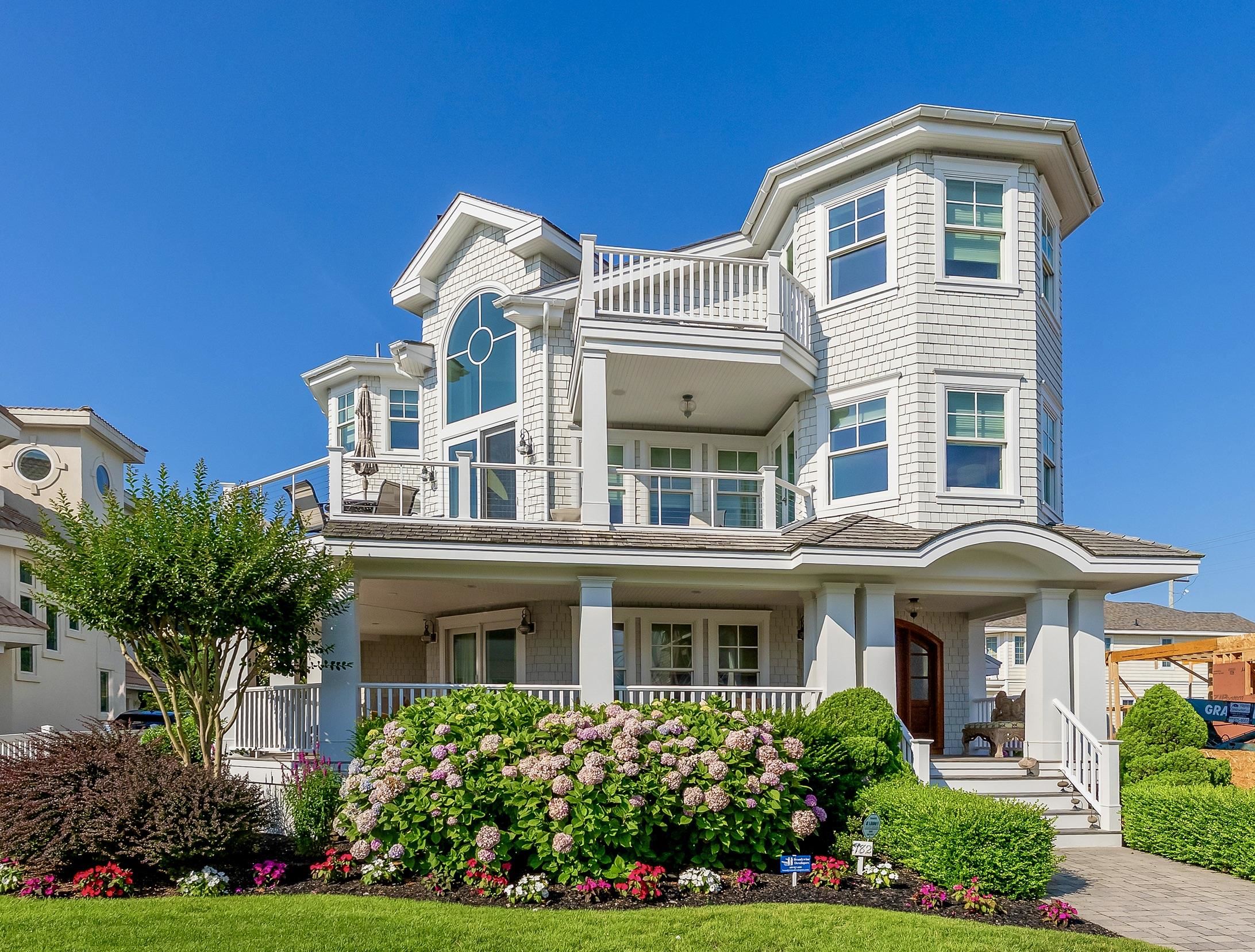 Welcome to 182 65th Street, a stunning summer haven located only 2 homes from Avalon's premier south end 65th St. beach.  Completed in 2013, the home was expertly crafted by architect Paul Kiss of OSK Architects, meticulously built and continuously updated by Brandywine Builders, and professionally decorated by Joyce Pearl of Interior Concepts Design of MD. The high-quality design features and bespoke materials reflect superior craftsmanship in every detail. The decor captures a tranquil island-inspired vibe intertwined with refined finishes, all in pristine condition due to very light seasonal usage by owners - home presents like it was just finished very recently and is the ideal beach retreat for creating cherished family memories for generations to come.        The three stories flow seamlessly with hardwood floors, installed and honed in place throughout all areas of the home. Entering from the driveway you will find a four-stop elevator for convenient transport of luggage and groceries, plus an electric car charging outlet. Ascend the front steps to a mahogany wraparound deck where a grand custom entry door awaits. Entering the first floor, French doors lead into a spacious family room with wet bar and sliders that open onto the covered front deck. Down the hall, three generously sized bedrooms each equipped with ensuite baths await, one enhanced by a decorative wall of opaque dune reeds and grasses evocative of a serene spa atmosphere. The two rear bedrooms offer sliders leading to the four season back porch which opens directly to the backyard pool area. The porch features motorized shutters on all sides allowing for privacy and can be adjusted for open-air enjoyment. The full southern exposed pool is a standout feature complete with an "endless pool fast lane" w power cover for seasonal use.  Also on the first floor, a separate east side entrance leads into a full-size laundry room with side-by-side washer and dryer, ample storage closets and hall cabinetry housing the full home 'Creston' integrated technology system.       The second level showcases an impressive great room spanning the north and east sides of the home, complete with a wet bar, soaring cathedral ceiling, and gas fireplace with a dramatic wave inspired cove lighting fixture reaching to the ceiling. The great room offers sliders onto the front wraparound sundeck ideal for lounging and soaking in the breathtaking ocean views. The kitchen is designed for the culinary enthusiast, featuring premium cabinets, countertops, and appliances, including a custom built-in refrigerator. A second enclosed four season porch off the rear of the kitchen provides additional space for outdoor dining and motorized shutters for added privacy and protection during the off-season. This level also includes a junior master suite with its own access to the rear porch, as well as a charming turreted sitting area with plantation-style ceiling opening onto the front wraparound beach view deck.                                                 The third level master suite is the crowning jewel of this home.  Indulge in luxury with a full-sized ocean view gym featuring soundproof flooring, a private turreted room on the east side with it's own deck for morning coffee to take in the spectacular ocean sunrise, and a lavish master bath equipped with a jetted tub and heated floors. This owner’s retreat features an additional deck off the bathroom & bedroom, a separate powder room, gas fireplace, a wet bar, a second stacked washer-dryer, and spacious walk-in closet.                       With countless exceptional features,  182 65th Street is a must-visit property that embodies a luxurious tropical essence within a captivating coastal environment.  Offered furnished w exclusions.
