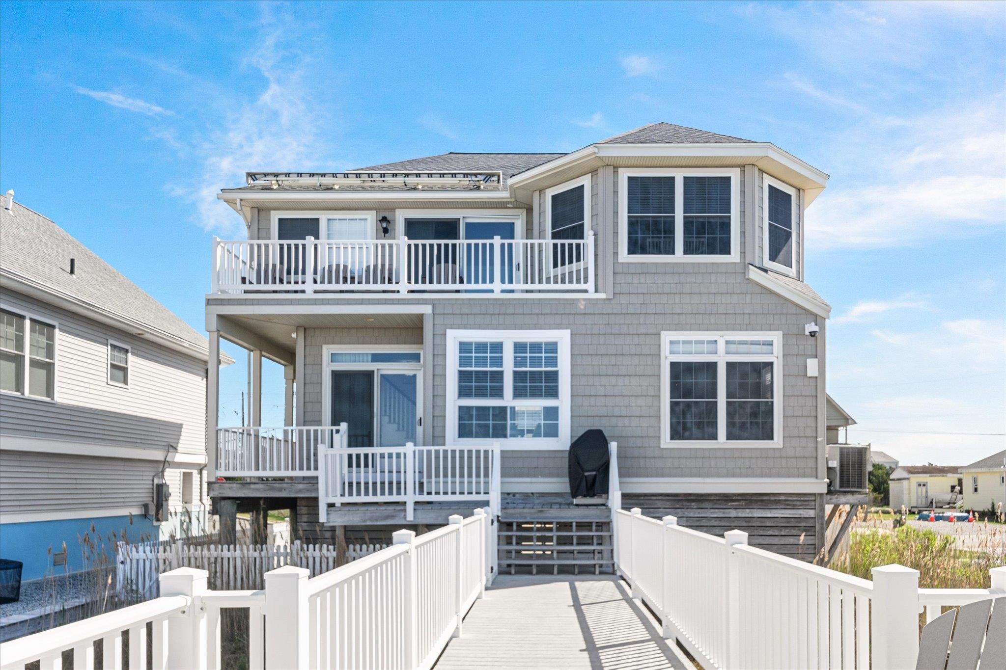 A boater’s paradise awaits at 11 Leonard's Lane. This beautifully renovated 3-bedroom, 2.5-bath bay front single-family home offers unobstructed water water/wetlands views and direct access to the open bay, delivering the perfect balance of comfort, style, and functionality. With a 20,000-pound boat lift, expansive under-home storage, and breathtaking views from multiple vantage points, this home captures the very essence of the Jersey Shore lifestyle.  Inside, the home radiates a fresh charm with a breezy, beach-inspired design. Hardwood floors run throughout, enhanced by custom millwork and tailored window treatments that add a refined feel. The kitchen is both beautiful and practical, featuring modern stainless steel appliances, marble countertops, and custom cabinetry—a space designed for both entertaining and everyday living. A Sonos sound system flows throughout the home, providing a rich and immersive audio, setting the mood from sunrise to sunset. The primary suite offers peaceful bay views and a soothing atmosphere, while the additional bedrooms are equally warm and inviting.  Step outside and immerse yourself in the full bay front experience—whether you're enjoying coffee beneath the motorized awning on the upper deck or rinsing off in the outdoor shower after a long day on the water. Recent and thoughtful upgrades include a 3-year-old roof, on-demand hot water heater, and a state-of-the-art security system for added comfort and peace of mind.  Ideally situated just a short drive from Avalon’s acclaimed beaches, vibrant dining scene, and boutique shopping, this home offers the perfect blend of coastal convenience and relaxed bay front living.  Move-in ready and masterfully updated, this home is your gateway to the Jersey shore waterfront lifestyle you've been dreaming of.