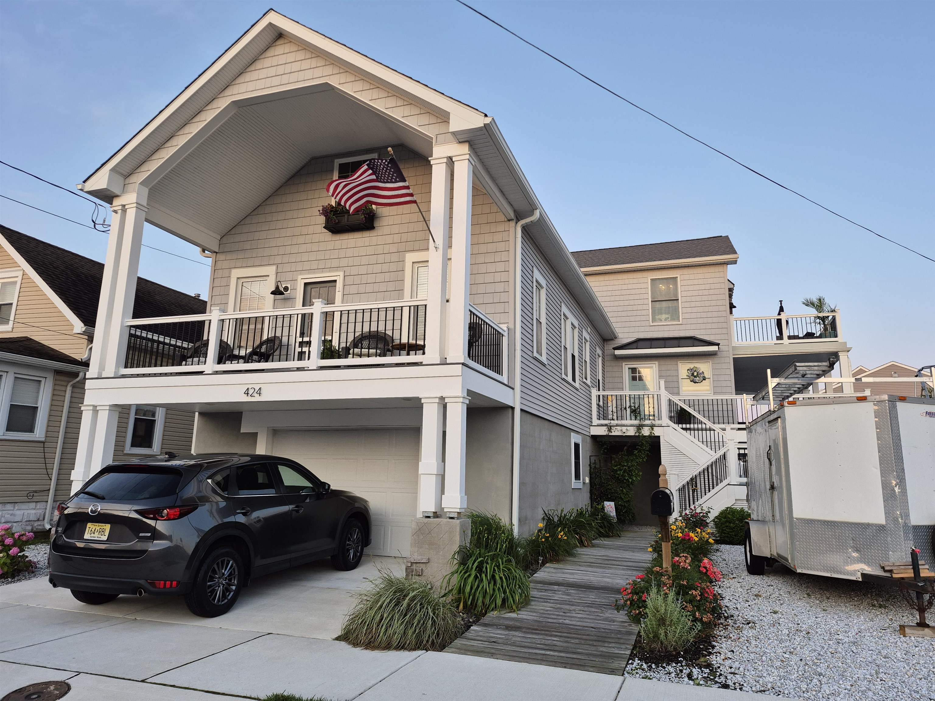 Custom craftsmanship meets beach-bungalow charm in this thoughtfully re-imagined 5 Bedroom 2.5 bath upside-down home. The 1920 cottage was lifted and expanded to showcase a sun-splashed great room beneath soaring ceilings, anchored by an indoor/outdoor gas fireplace. Two oversized sliders open to wrap-around decking with a covered dining alcove—ideal for summer entertaining—while a rooftop deck delivers postcard sunsets and front-row seats to Friday-night fireworks. Downstairs, the bedroom level centers on a generous primary suite with dual closets, private deck access, and a spa-style bath featuring a soaking tub and oversized tile walk-in shower. A flexible front bedroom doubles as a home office. An ingeniously repurposed wing of the original bungalow offers its own sitting room, kitchenette, three additional bedrooms, and a full bath—perfect for visiting guests or multigenerational living. Bonus spaces abound: a finished attic dormer for play or overflow sleep, a ground-level vestibule that opens to the backyard, and a heated-floor band room. The deep garage fits two cars when shelving is removed, while additional storage lines the entire lower level. The home also features a Whole House filtration system, delivering filtered water to every bath and faucet.  The backyard is a hidden gem, featuring two cherry trees, a peach tree, two apple trees, a fig tree, raspberries, strawberries and blackberry bushes—with plenty of room left for your dream garden. Great neighborhood, close to Wildwood's finest waterfront dining establishments and the New Marina at the Wharf.  Move-in ready, coming fully furnished and designed for effortless coastal living—this is the rare home that balances character with modern convenience. Easy to show. Lockbox. OPEN HOUSE SATURDAY JUNE 21ST 10:00 AM- 1:00 PM Seller is a Licensed New Jersey Real Estate Agent