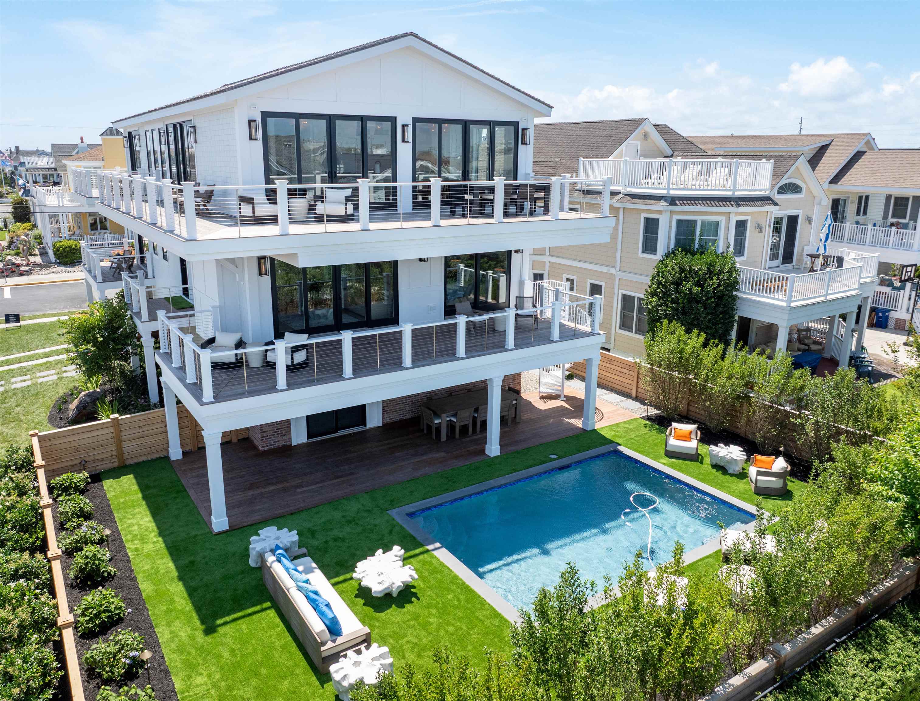 Yet another masterpiece comes to market for Summer 2025.  Enjoy sweeping view of the Atlantic Ocean from both the First and Second floors at this magnificent corner location just steps from the beach at 84th Street and First Avenue!!   With an upside-down floor plan that accentuates the expansive 180-degree view corridor, this home has it all.  Six bedrooms, including one double bunk room, will feature natural stone and porcelain tiled ensuite baths, Thibault wall coverings, custom woodworking and trim, plantation shutters and motorized blinds.  Soaring vaulted ceilings and oversized windows and sliders in the combined living, dining and kitchen areas on the second floor invite the natural beauty that surrounds this home indoors.  A separate and more intimate family room on the first floor overlooks the expansive pool area patio out back.  A summer kitchen / grille station will also allow for poolside entertaining after a relaxing day on the beach.   Other amenities include: Lifetime Standing Seam Metal Roof & Maintenance Free Fiber Cement Composite Siding; Sub-Zero / Wolf Appliances, Finest quality flush inset cabinetry with 5/4" doors, Kohler plumbing fixtures, Wire brushed white oak engineered hardwood flooring throughout, 3 stop elevator, Sonos A/V system, Oversized 14' x 24 gunite pool by Avalon Pools, Inc., 295 SF of crawl space area at 8 foot height for FEMA access to ground level elevator; 1,200 SF of area at 6 foot height in crawl space for storage; 600 SF of decks with views at second floor, Landscaping by Garden Greenhouse and Nursery.  Fully furnished inside and out by Restoration Hardware.