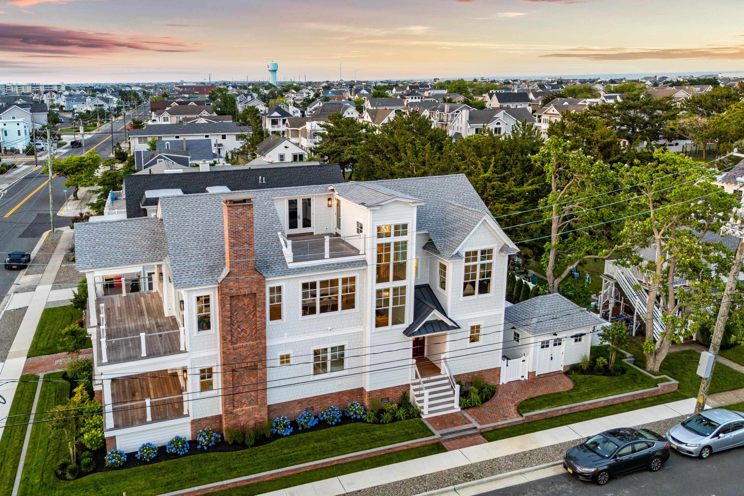 Nestled in the heart of Stone Harbor, 274 106th Street is a newly constructed residence designed by the renowned OSK Design Partners, offering the ultimate in coastal sophistication and luxury. This six-bedroom, six-bathroom sanctuary features sweeping views of Carnival Bay, where the sun sets in breathtaking fashion. Perfectly positioned for those seeking the finest in shore living, the home is located just ten blocks from 96th Street, offering both proximity to restaurants and shops and privacy.  Set on a coveted corner lot with an abundance of light and air, this exceptional property spans 3,230 square feet of meticulously designed living space. Fully furnished and move-in ready, the home seamlessly blends modern elegance with the timeless coastal charm of Stone Harbor. The focal point of this remarkable home is the expansive, unobstructed southwestern-facing bay views, visible from multiple decks spanning over 1,400 square feet. Whether you're sipping coffee at sunrise or enjoying cocktails at sunset, the panoramic views provide a serene and unparalleled backdrop for everyday living.  The spacious interior is thoughtfully designed with six generously sized bedrooms, four full bathrooms, and two powder rooms, offering privacy and comfort for both family and guests. On the first floor, the oversized lot allows for a uniquely large family room, complete with coffered ceilings and a white oak wet bar with under-counter Sub-Zero refrigeration. In addition to the family room, there is a spacious laundry room and a powder room with its own convenient, tiled entrance off the pool. The first floor also features four bedroom suites, two of which have private access to the front covered deck with bay views. The fourth bedroom is a must-have custom bunk room for children or grandchildren. Lastly, a versatile, cozy space is currently designed as an office but offers endless possibilities— whether transformed into a walk-in wine cellar or repurposed for additional storage to suit your needs.  At the heart of the home is the gourmet kitchen, outfitted with top-of-the-line Sub-Zero, Wolf, and Bosch appliances, custom maple cabinetry, a walk-in pantry, and a large, functional center island. Adjacent to the kitchen, the two-story great room features vaulted ceilings, exquisite tongue-and-groove wood paneling, a gas fireplace, expansive dining area, and oversized windows that bathe the space in natural light while framing the stunning bay views. Rounding out the second story, you'll find an additional guest bedroom with southeastern exposure, as well as the luxurious primary suite. The primary suite is a true retreat, complete with a private covered deck, walk-in closet, custom bath with a double vanity, and a spa-like walk-in shower.  Step outside into your own private backyard oasis, featuring a custom gunite pool with a six-person spa and sun shelf, all framed by a luxurious sandblasted marble patio. Adjacent to the pool, a charming cabana with a wet bar and ample storage provides an ideal space for poolside gatherings or quiet retreat. Additionally, the third-floor roof deck offers breathtaking panoramic views, with a convenient wet bar just inside—perfect for enjoying sunset cocktails during countless happy hours. This home is equipped with an audio system, HD CCTV security cameras, and sophisticated exterior lighting, elevating both convenience and ambiance. Throughout the home, custom cabinetry, premium finishes, and impeccable craftsmanship are evident, ensuring an unparalleled level of luxury.  Perfectly situated in the quieter south end of the island, 274 106th Street offers the rare combination of privacy and proximity to all that Stone Harbor has to offer. Whether you are looking to entertain, unwind, or simply enjoy the beauty of coastal living, this exceptional residence provides it all.