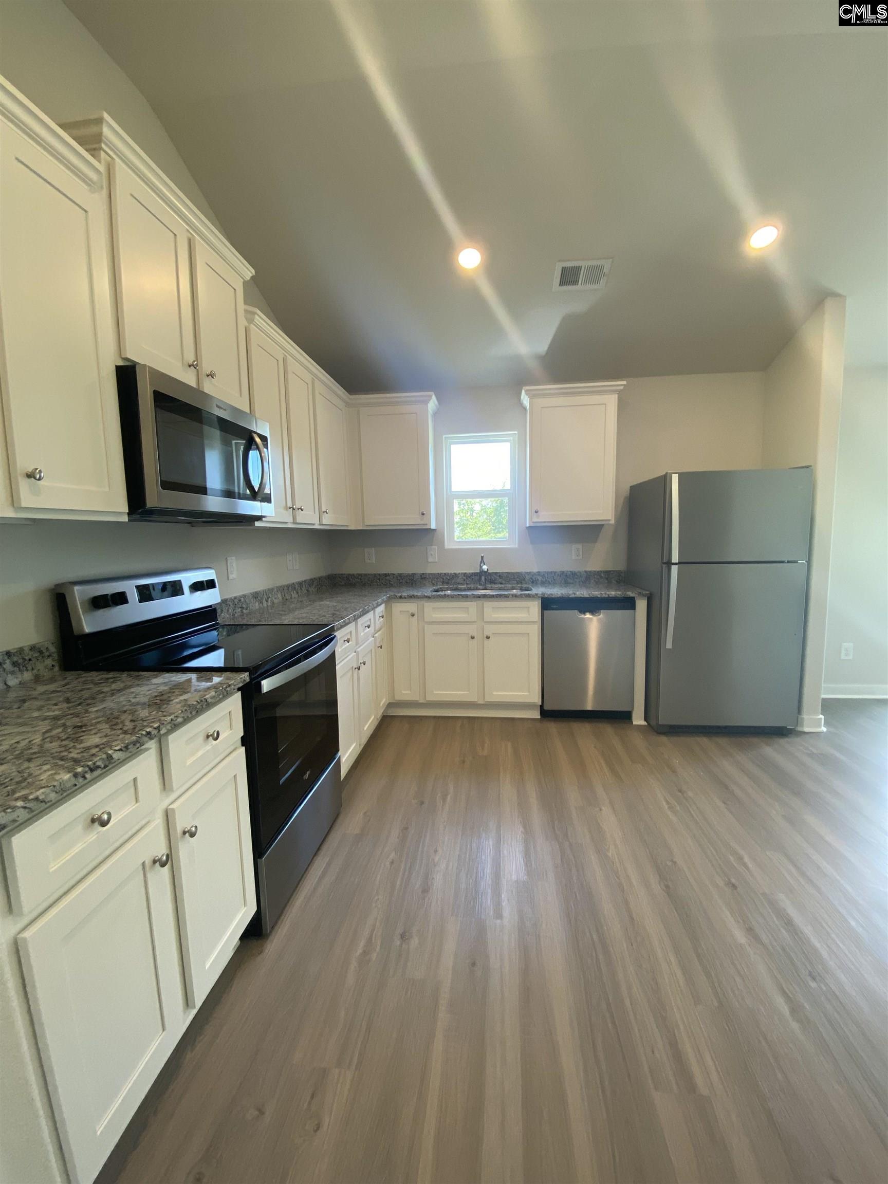 The kitchen features granite countertops and a full suite of stainless steel appliances.