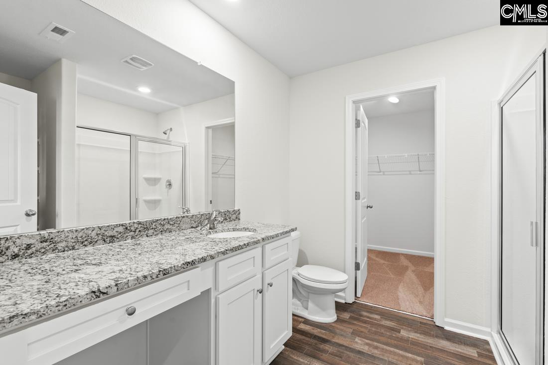 A walk-in shower and a large vanity are showcased in the master bath.