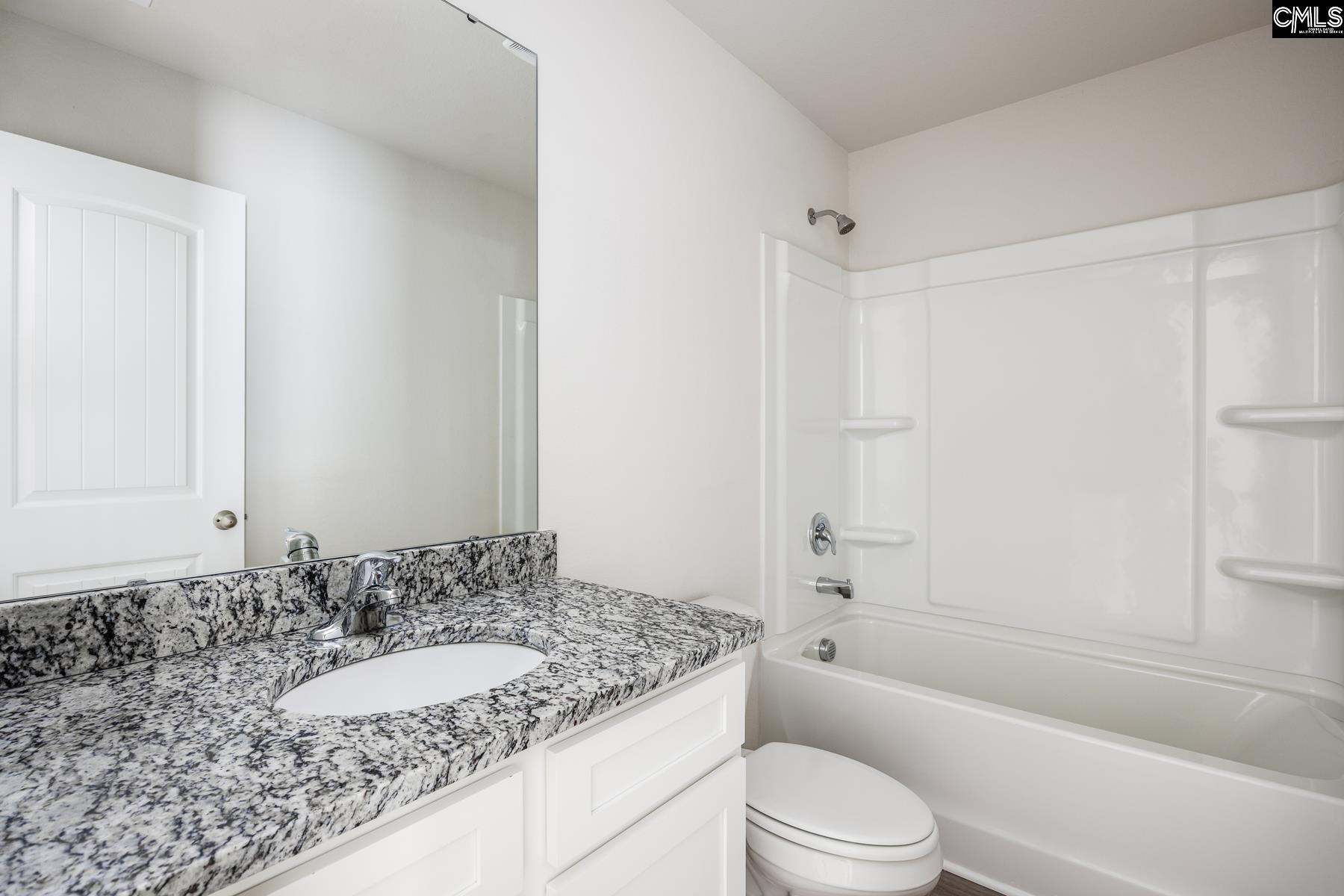 The second bathroom features a spacious vanity and tub/shower.