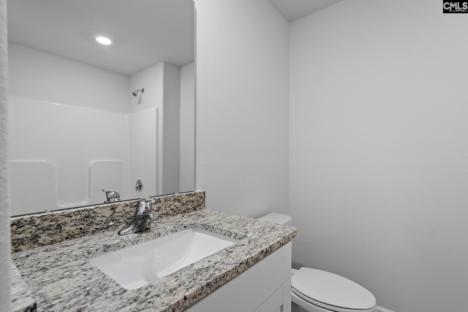 The second bathroom features a spacious vanity and tub/shower.