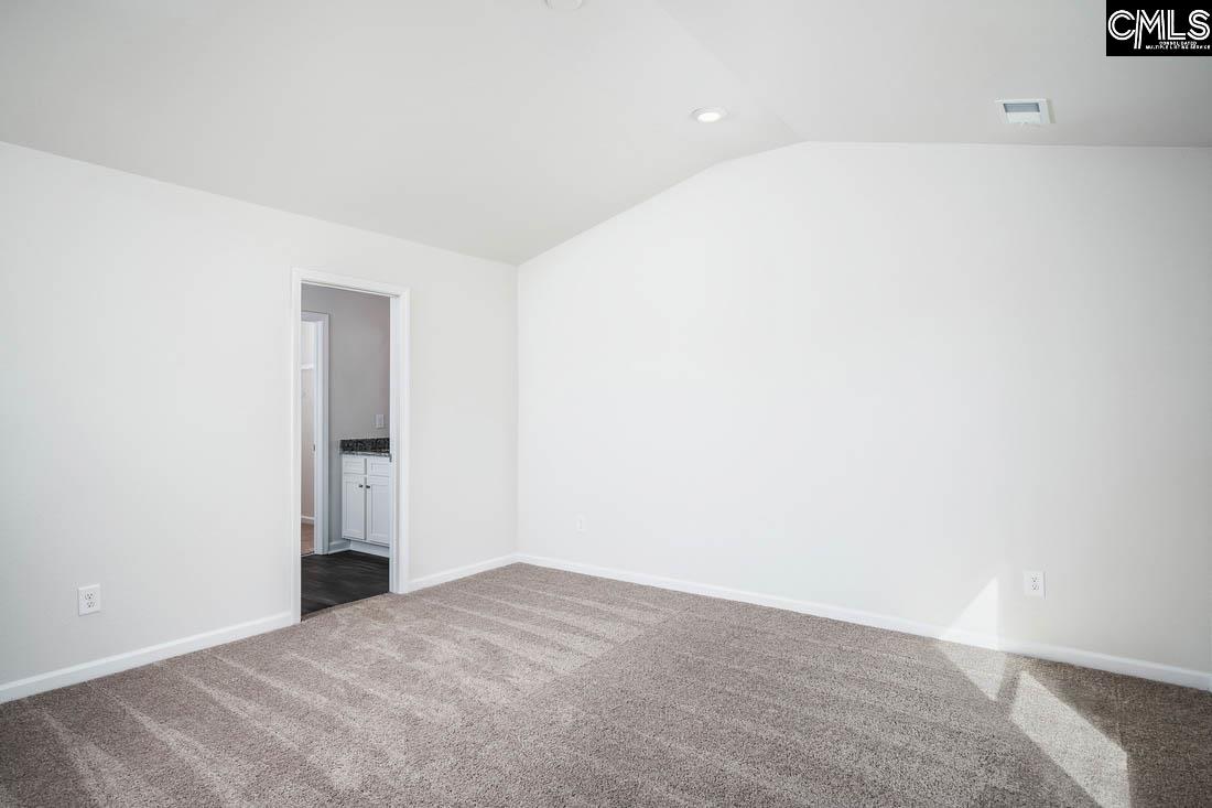 The master bedroom is spacious with a vaulted ceiling and two windows.