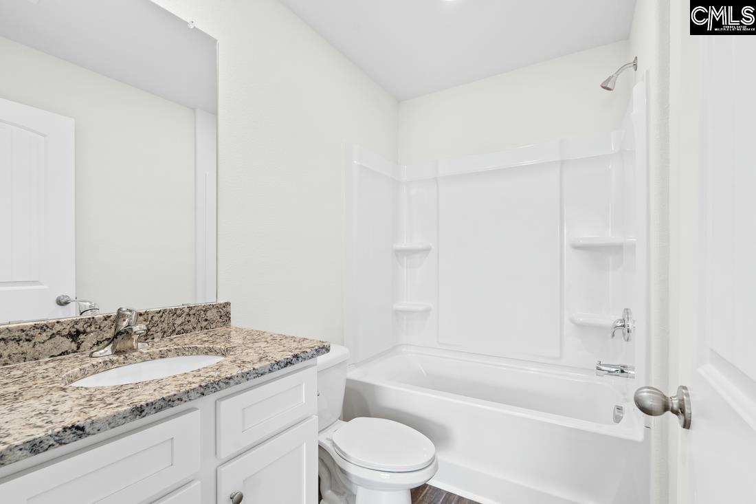 The second bathroom features a spacious vanity and tub/shower.