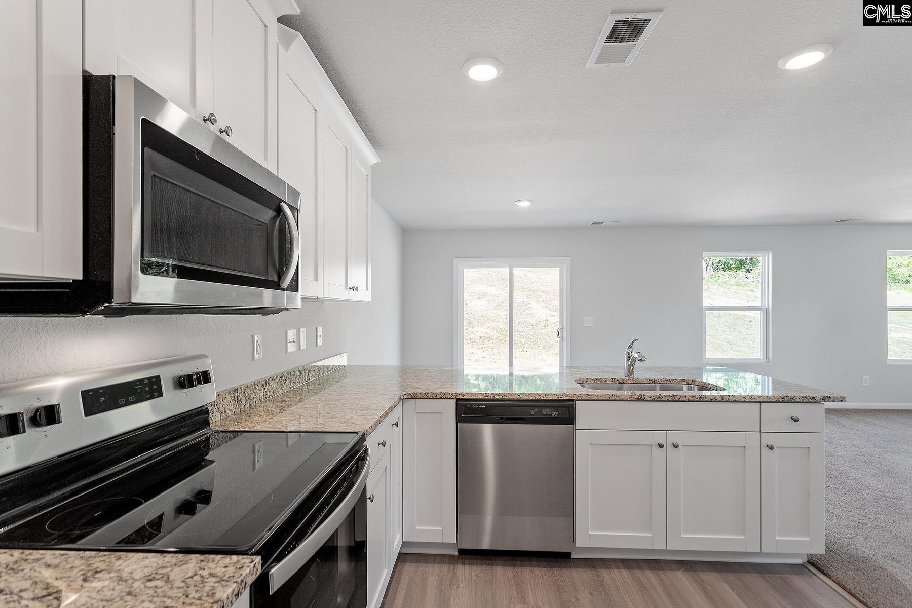 The kitchen features granite countertops and a full suite of stainless steel appliances.