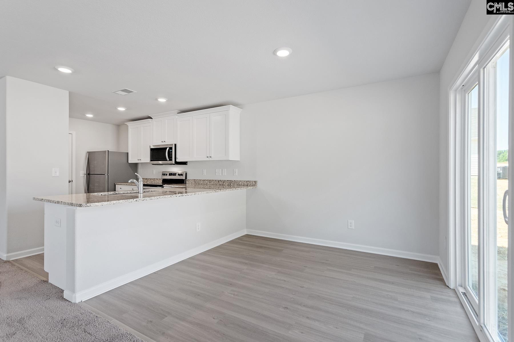 Located off the kitchen, the dining nook showcases luxury vinyl plank flooring and a large window.
