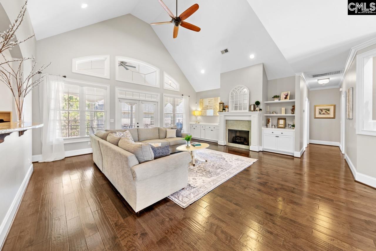 spacious layout with abundant natural light, hardwood flooring, vaulted ceilings, and a fireplace.