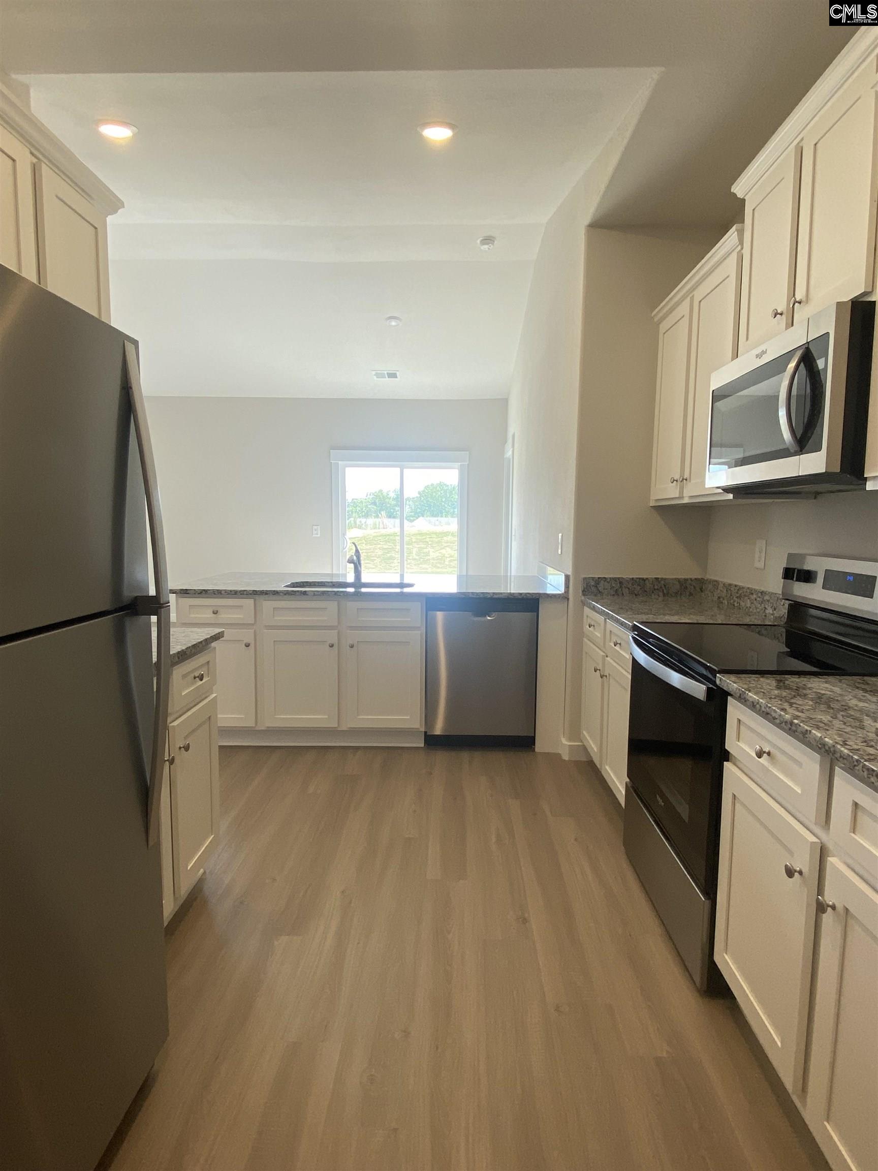 The kitchen features granite countertops and a full suite of stainless steel appliances.