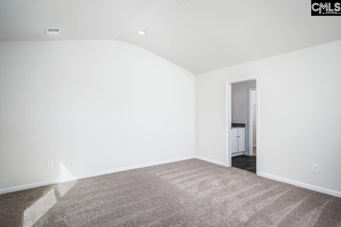 The master bedroom is spacious with a vaulted ceiling and two windows.