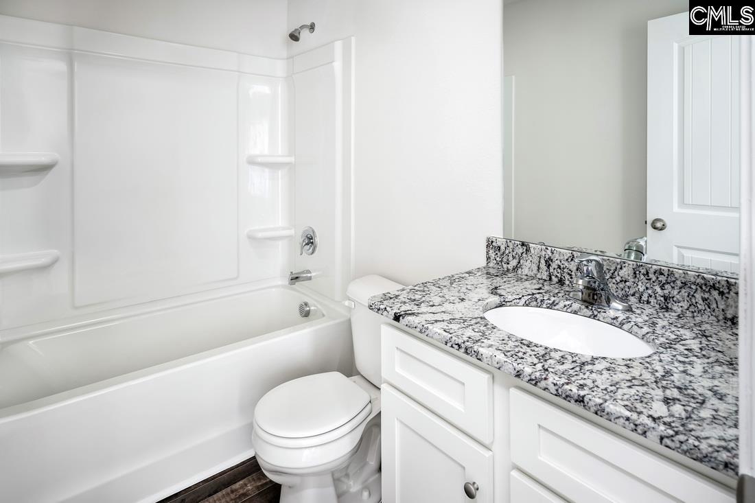 The second bathroom features a spacious vanity and tub/shower.