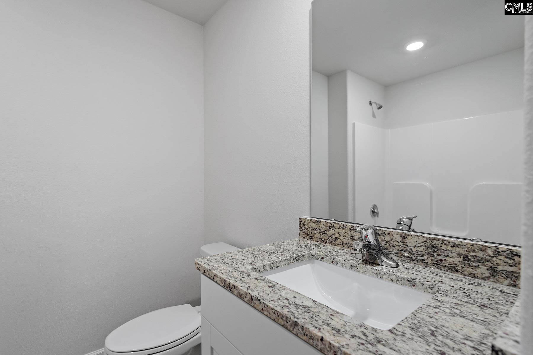 The second bathroom features a spacious vanity and tub/shower.