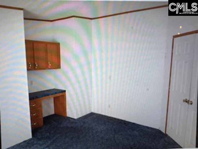 Bonus/Office room from inside the room, has a built-in desk and cabinets hung above.