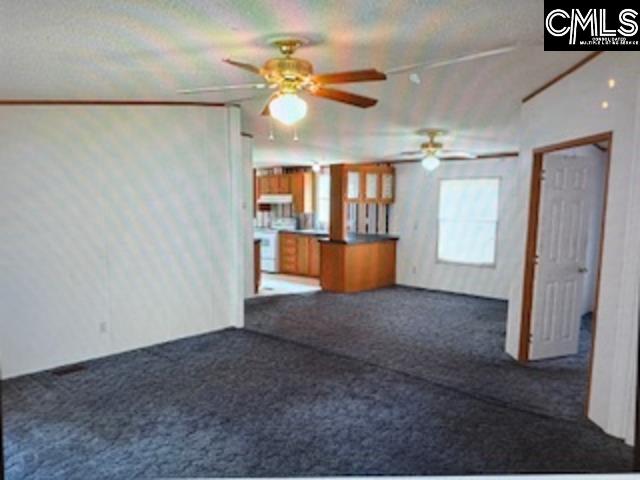 View from the front door into the residence, showing the living room into the dining room & kitchen