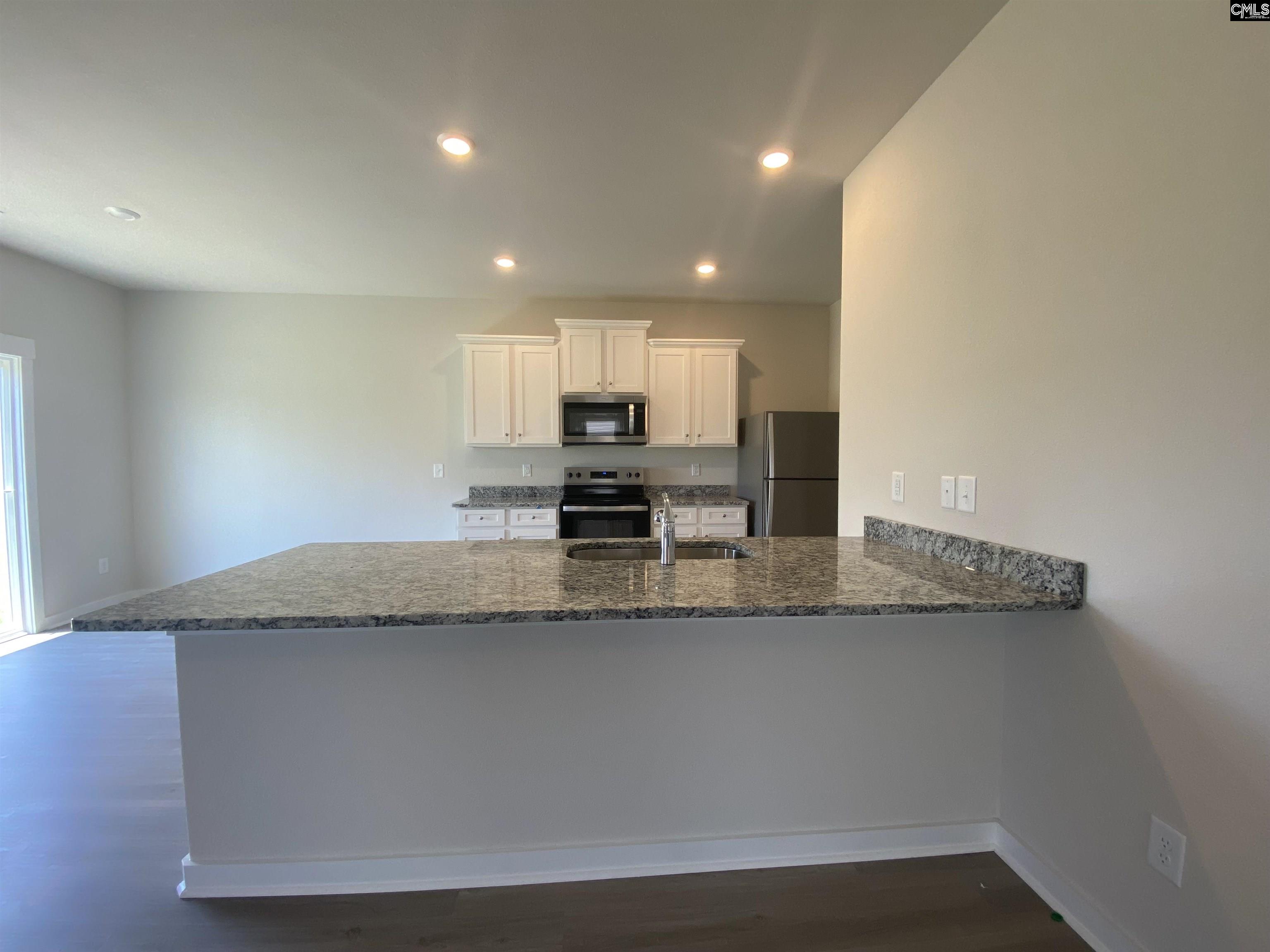 The kitchen features granite countertops and a full suite of stainless steel appliances.