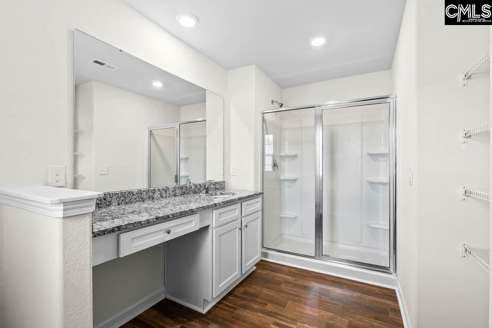 A walk-in shower and a large vanity are showcased in the master bath.