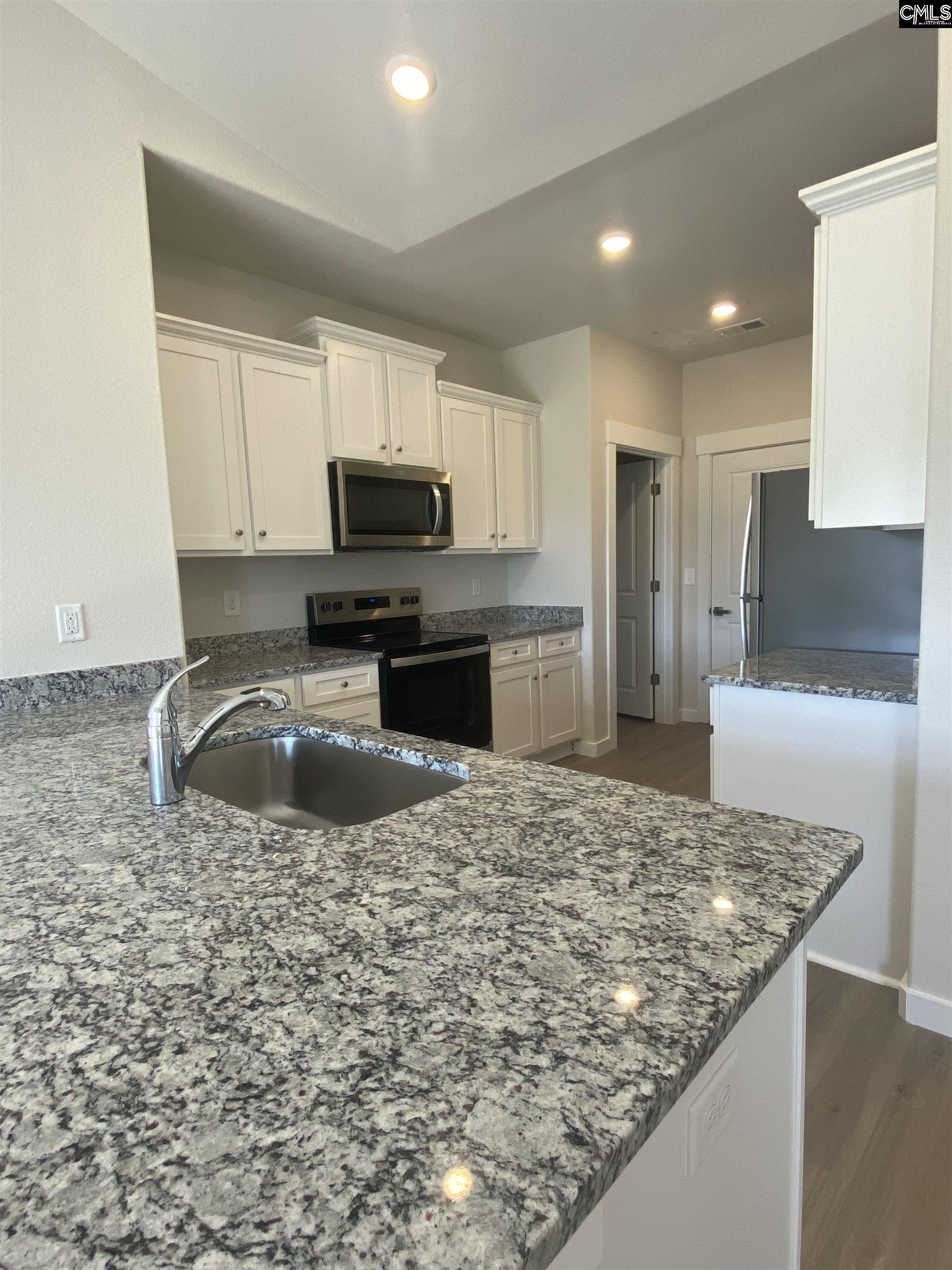 The kitchen features granite countertops and a full suite of stainless steel appliances.