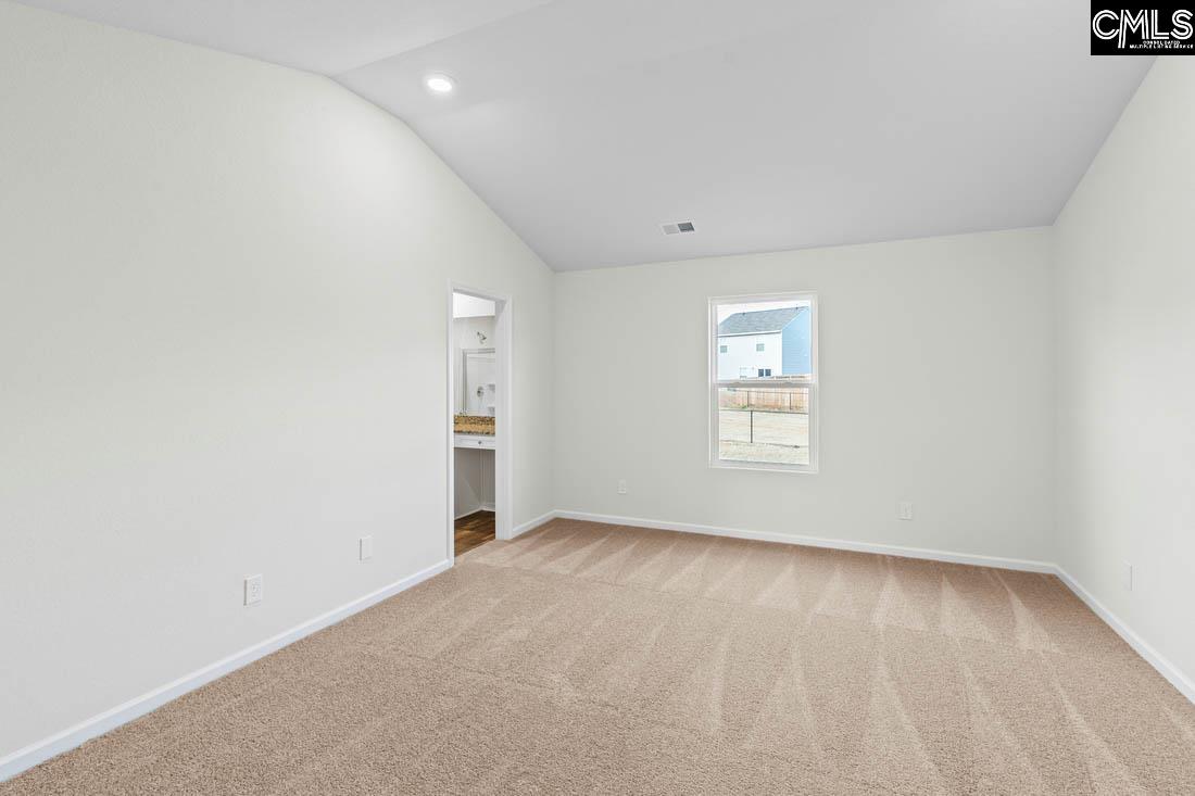 The master bedroom is spacious with a vaulted ceiling and two windows.