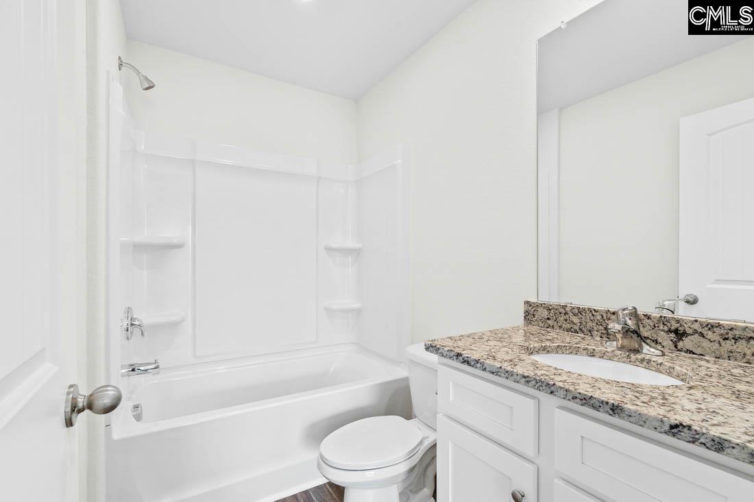 The second bathroom features a spacious vanity and tub/shower.