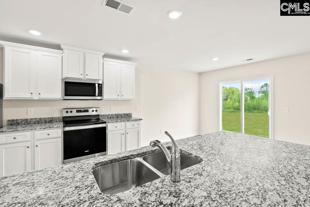 The kitchen features granite countertops, island, and a full suite of stainless steel appliances.