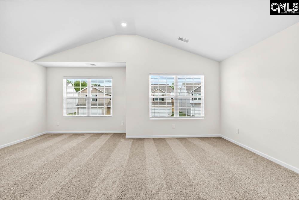 The master bedroom is spacious with a vaulted ceiling and two windows.