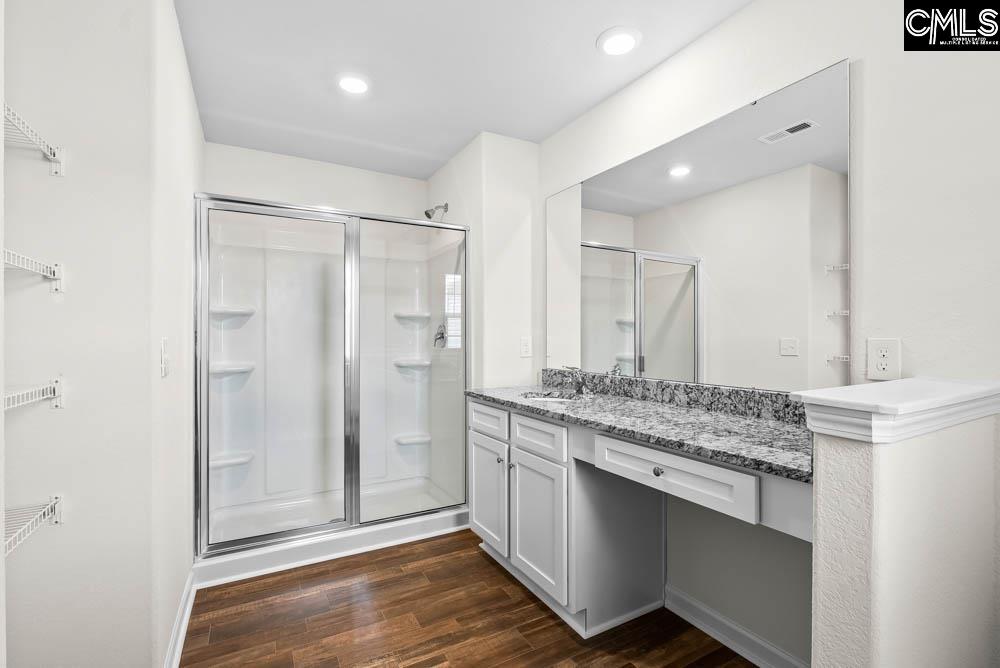 A walk-in shower and a large vanity are showcased in the master bath.