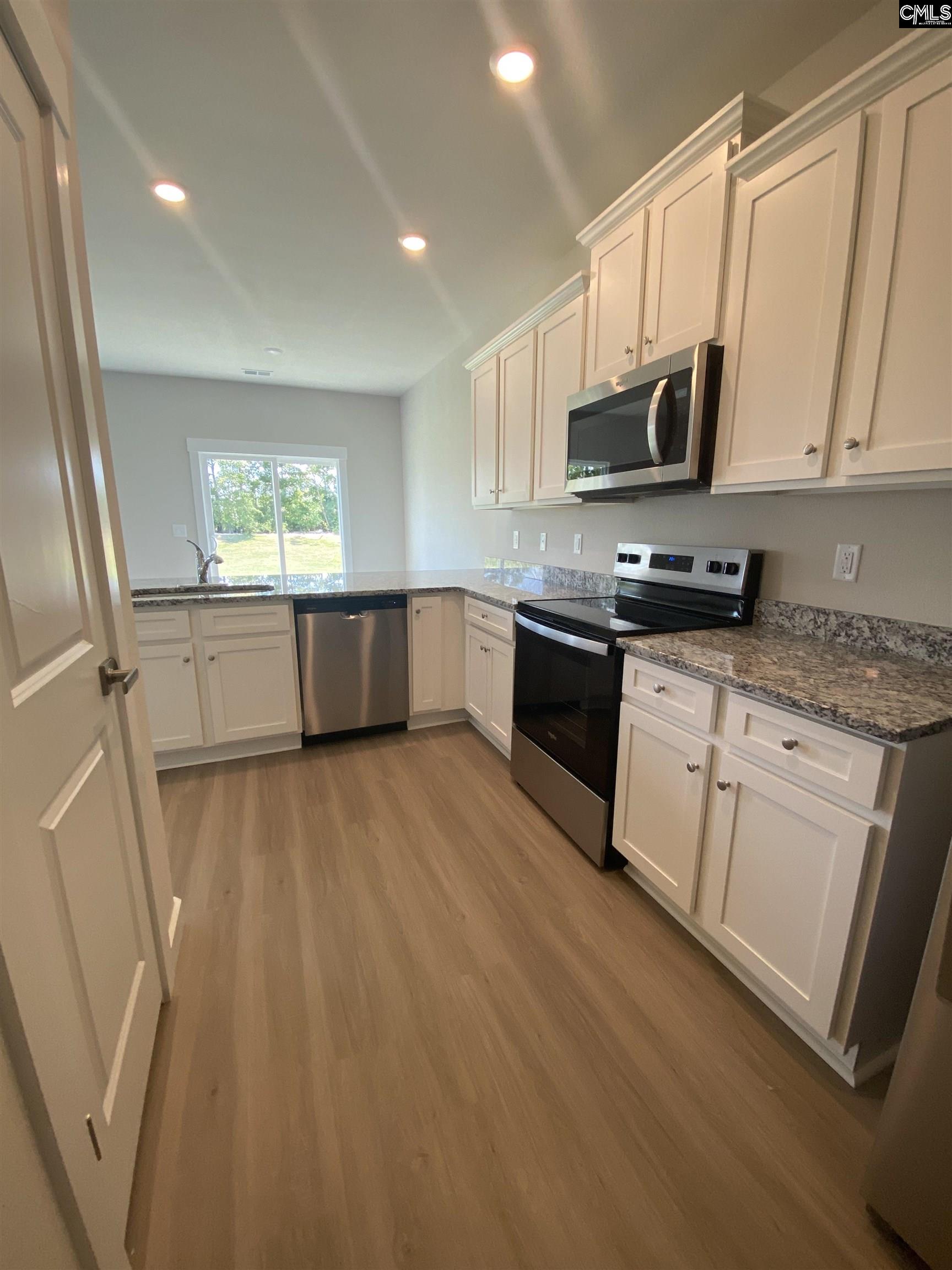 The kitchen features granite countertops and a full suite of stainless steel appliances.
