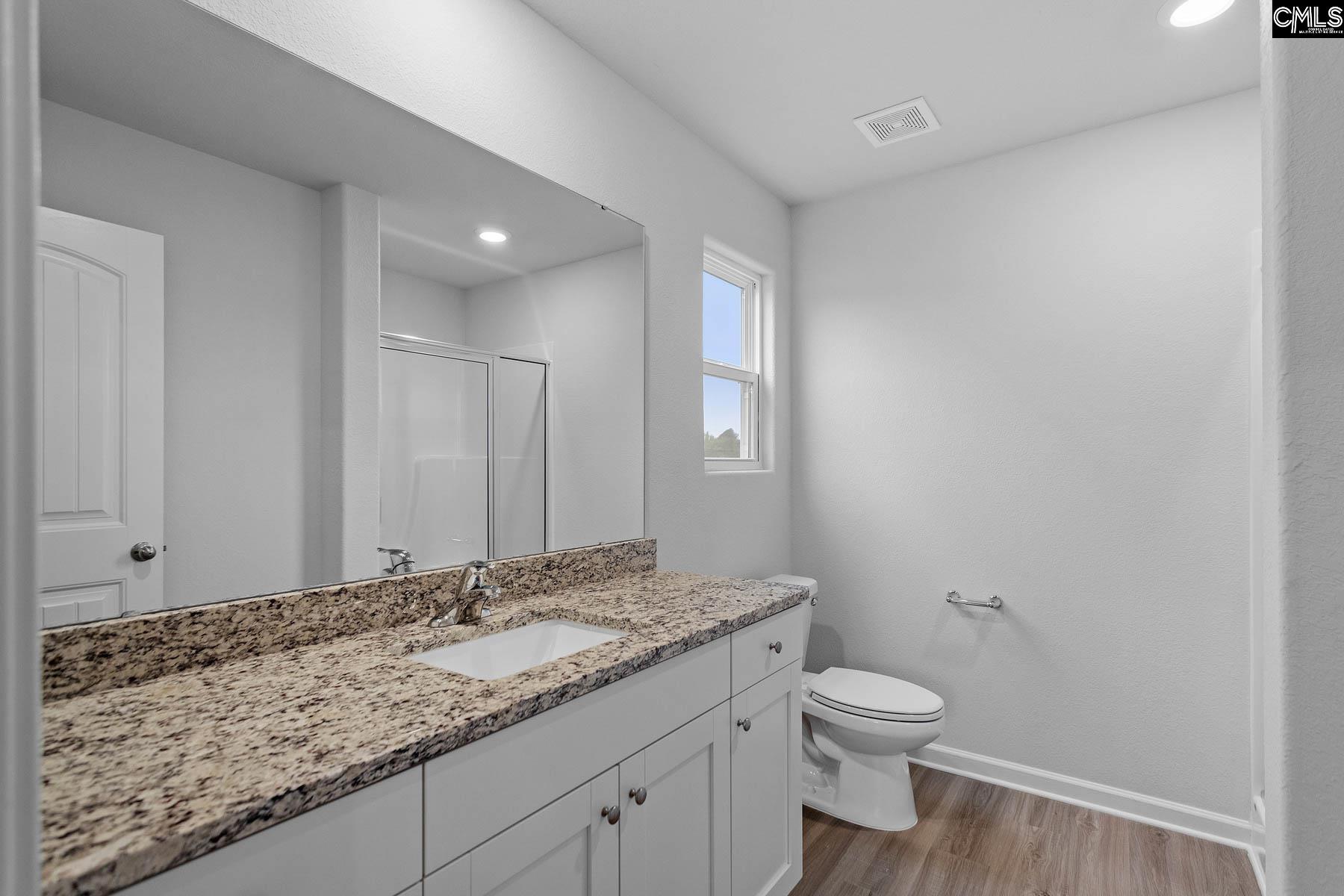 A walk-in shower and a large vanity are showcased in the master bath.
