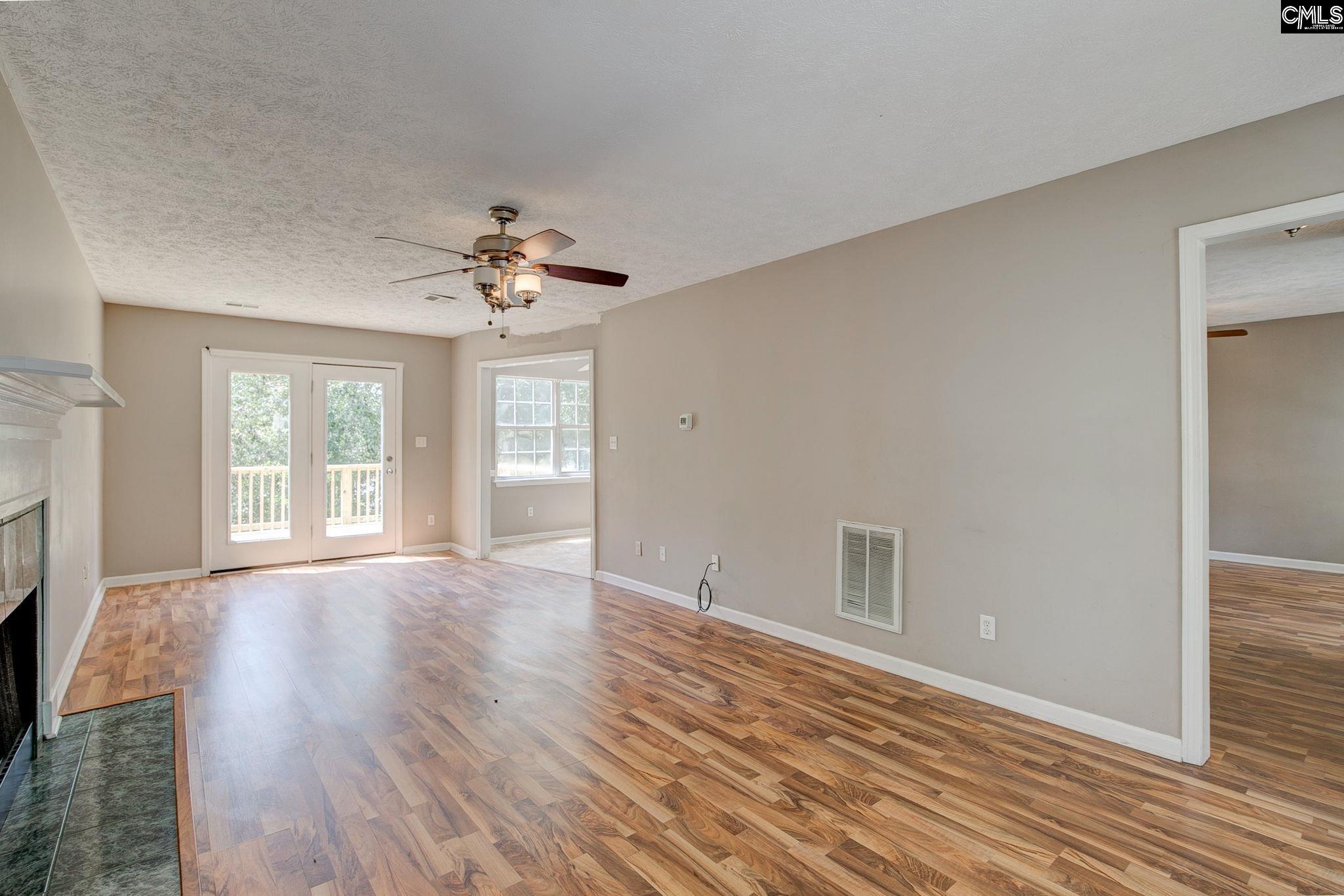 Spacious great room with laminates and gas fireplace, french doors to new deck