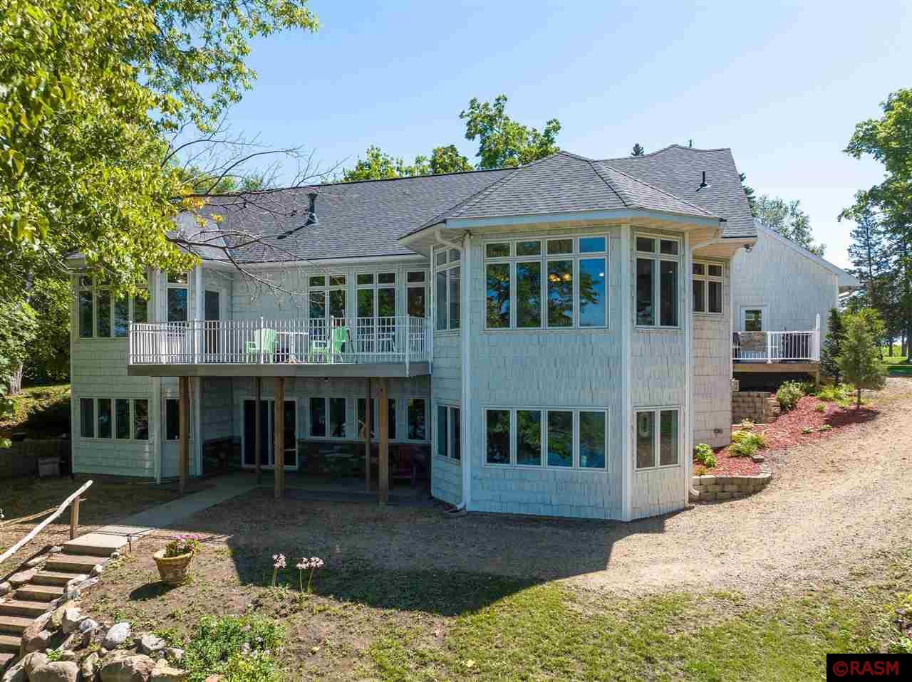 First time on the market - this stunning 5-bedroom, 4-bath home with nearly 250-feet of shoreline is a must see! An impressive amount of windows  overlooking the lake make this home bright and airy all year around. Main level open concept living, kitchen and dining areas with gas fireplace and polished hardwood floors. Butler's pantry, laundry/mudroom area to the rear of the kitchen leads to the attached 3-stall garage. Large walk-up unfinished loft with loads of natural light above the garage offers exciting potential.  The opposite wing of the main level consists of Owner's suite, guest bedroom and guest bath.  Lower level is equipped with heated and stained concrete flooring with three additional bedrooms, full bath and family room with a 2nd gas fireplace.  Stroll out from the family room to the patio and continue on to the well-maintained sandy shoreline with two docks. Potential for a sixth bedroom in the lower level.  There is so much to love about this home - set up your private showing today!