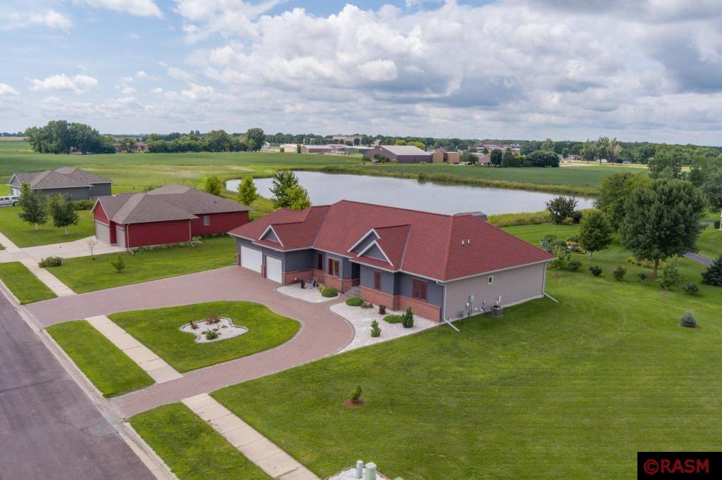 This custom built rambler is sprawling with over 4,000 square foot of living space! From the moment you approach the home you will be captivated by its beautiful curb appeal! Combining an attractive mix of brick and vinyl exterior, paver horseshoe driveway and meticulous landscaping. Interior welcomes you with all the desired amenities; Large kitchen with center island and an abundance of cabinets, dinette area, formal dining room, family room. The primary suite offers a walk in closet and private full bath with a separate shower and an additional combo shower/tub. Two bedrooms, main floor laundry, living room and family room complete the main floor. Lower level features daylight windows, a wet bar, fourth bedroom and lots of space for recreation and storage. You will enjoy the evenings on the patio over looking the large yard and pond. Triple attached garage provides extra room for storage. This one checks all the boxes for everything you need!