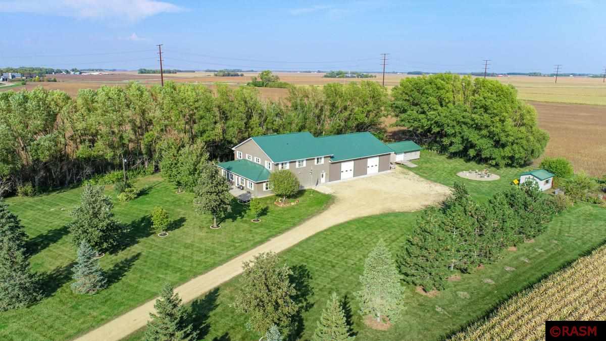 This is not a shouse! Experience the epitome of modern country living! Discover this 3-acre property featuring a 3-bed/5-bath home and a 50x60 attached garage with 12ft overhead doors; the ultimate hobby haven! Just south 1 mile off Hwy 14 on a paved road, 3 miles to North Mankato and a few hops to North Links Golf Course.  Sleek metal roof and Hardie board siding.  Mudroom complete with a convenient drop zone for outdoor gear and a commercial stainless sink ideal for clean up. The kitchen showcases stainless steel appliances, pantry, wine bar, exquisite quartz countertops and a massive granite island for all your storage needs. Dinette, living room, primary bedroom, front porch with hot tub and 1/2 bath complete the main level.  Upper level includes a large family room and two bedrooms, each with their own private bathroom.  Enjoy ultimate comfort with in-floor heating with three separately controlled zones; garage, main level living and front porch.  Forced air furnace for heat/air conditioning with separate zones for lower and upper living areas. The attached garage is something to talk about! Full bar set up, a workshop and laundry with 3/4 bath, along with two large spare rooms upstairs, which could be used as theater/workout/hobby room. In-ground sprinkler system, with 11 zones and over 70 sprinkler heads. Septic is compliant.  Additional 20x30 shed with ramp and overhead door plus a 12x18 garden shed. Great location for a business opportunity! Agent is owner.