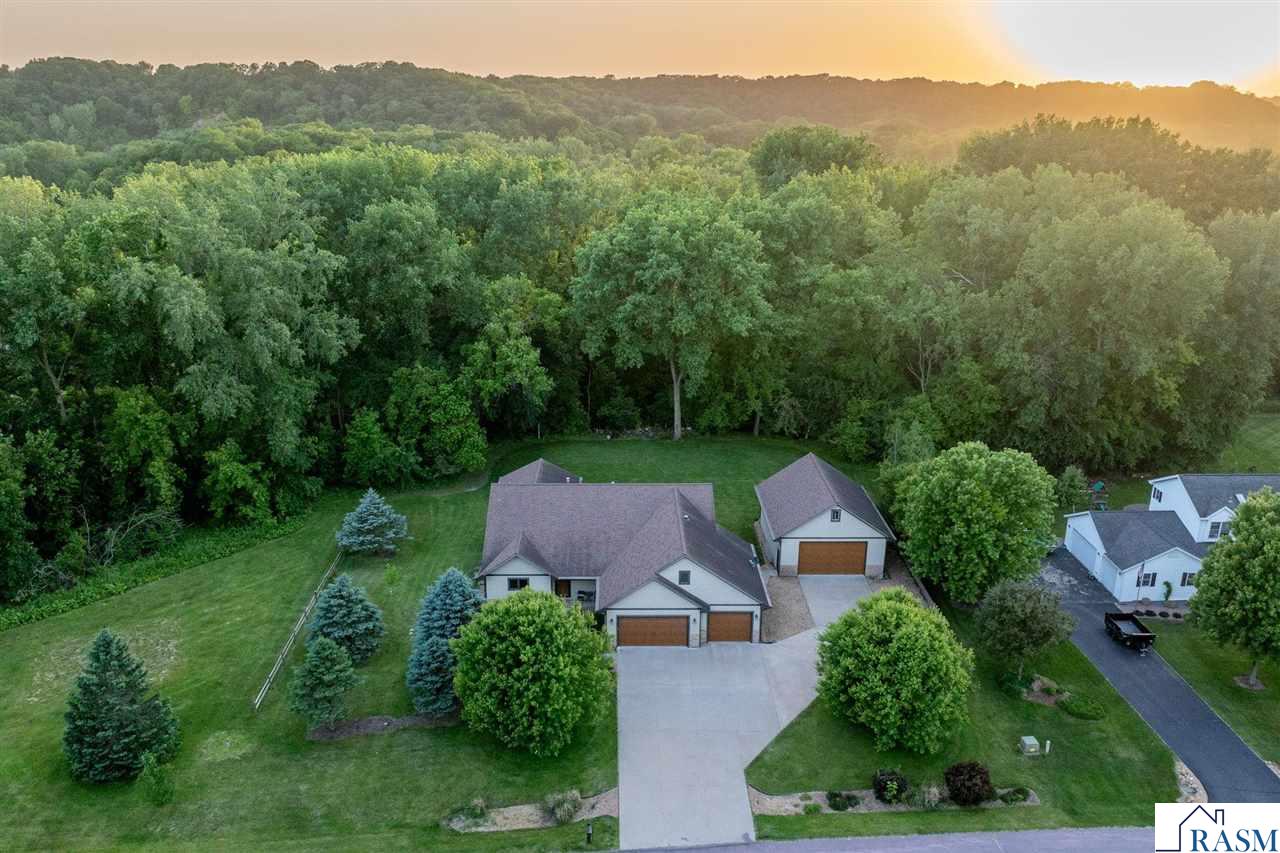 Welcome to your dream home! Just minutes from Mankato, nestled in the tranquil Cedar Meadows subdivision, this stunning multi-level residence offers nearly 4,000 sq ft of luxurious living space on a spacious 1-acre lot. Featuring 5 spacious bedrooms, 3 baths, an attached 3-car garage, and an additional 2-car detached garage with loft storage above, this home has it all. The main floor is perfect for entertaining, with a modern kitchen, dining room, living room, and a three-season porch. You will also appreciate the main level mudroom with built-in cubbies and laundry room. The upper level boasts a grand master suite with a private TV room and office/den, a walk-in closet, plus a lavish master bath with a Jacuzzi bathtub. This level also includes two additional bedrooms and a full bath. The lower level offers two more bedrooms, one of which can be used as a home office, a full bath, and a spacious family room. Descend another set of stairs to discover the ultimate entertainment room, complete with a home theatre featuring a 10' projection screen and surround sound with included theatre seating. This basement level also features an exercise room with a cushioned rubber floor. The heated three-stall garage is accessible through the mudroom and from the lower level. The detached garage includes a loft ideal for storage or conversion into additional living space. Residents of the Cedar Meadows subdivision enjoy access to 55 recreational acres, perfect for outdoor recreation including 4-wheeling and kayaking on the Cobb River. Additional amenities include whole house wired for generator, a hot tub that is included, in-ground sprinkler system, and alarm system with yard security cameras. This property offers a unique blend of luxury, space, and outdoor adventure, making it the perfect place to call home.