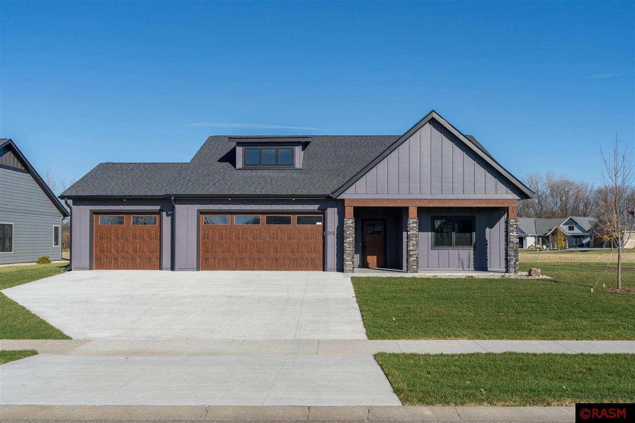 Discover your dream home with this beautifully crafted new construction patio home in the Miller Creek subdivision. This single-level beauty features 9' ceilings, an inviting open-concept floor plan, and modern amenities designed for comfort and style. As you step through the foyer, you'll be greeted by a custom-built hook wall and bench, stylishly accented with wallpaper and durable hard-surface flooring throughout. The spacious living room boasts a cozy gas fireplace, flanked by large windows that flood the space with natural light. Adjacent to the living area, the dining room opens to the backyard through a patio door, offering a seamless indoor-outdoor living experience. The heart of this home is the beautiful kitchen, complete with an oversized island with seating, quartz countertops, a tiled backsplash, and sleek stainless-steel appliances. This space is as functional as it is beautiful. The primary suite offers a serene retreat with a custom-tiled shower, double vanity, and a spacious walk-in closet. Two additional bedrooms, a full hall bath, and a laundry room with a sink complete the thoughtfully designed main level. The triple-stall insulated garage includes an unfinished bonus room above, ready to be customized to suit your needs. Outside, enjoy professional landscaping with shrubs, perennials, and a rear patio. Every detail of this home has been professionally designed with custom finishes that blend elegance and functionality. Schedule your showing today and make this house your home!