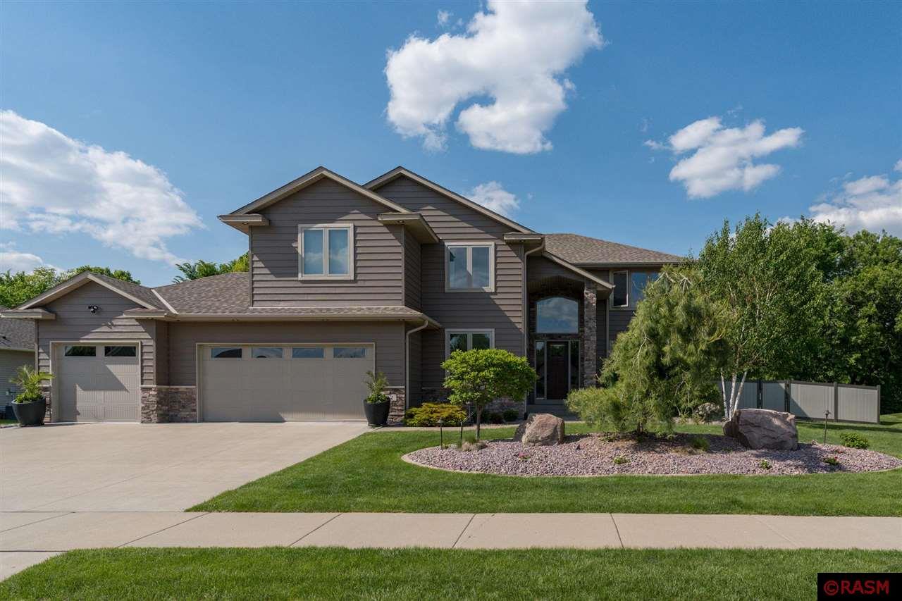 Stunning, custom-built 2-Story home located in "The Reserve" neighborhood in Upper North Mankato. Built in 2014 and meticulously maintained, this home offers nearly 4,600 sf and is situated on a professionally landscaped ravine lot, offering both privacy & beauty. The home's main floor is highlighted by the great room with 18' ceilings, floor to ceiling stone fireplace & motorized blinds.  Gourmet kitchen that features granite countertops, KitchenAid stainless-steel appliances & tiled backsplash. Located just off the kitchen is the recently added 3-season porch w/ Trex flooring & hot tub. Finishing out the main floor is the office w/ French doors, formal living/dining room, 1/2 bath & laundry/mudroom. Moving upstairs, the luxurious primary suite offers a full-size custom closet, primary bath w/ spa-style steam shower. Also located upstairs are 3 additional bedrooms and full bath. The basement offers a spacious family room w/ gas fireplace, wet-bar, two additional bedrooms, 3/4 bath, full gym w/ rubber floors, large storage room & mechanical/utility room. Additional features & recent updates to the home include: 20' x 40' In-ground saltwater pool w/diving board & motorized cover; Surround sound w/ buried subwoofer; Aluminum fencing; Insulated, finished & heated 3-Car garage; Andersen Windows, Hunter Blinds; Beam central vacuum; Dual-Zone Heating & Cooling with Smart Thermostats; Tankless water heater (2023); Advanced Security System & Smart Garage Access; Reverse Osmosis water filtration system with dual holding tanks; Gutters tied and tiled to ravine for optimal drainage; 20' x 30' Trex deck w/lighting; 35' x 29' patio;  Gas line to grill; Sprinkler system w/ flower pot irrigation. This home truly checks all the boxes—elegance, functionality, and luxury upgrades, all in a prime location!