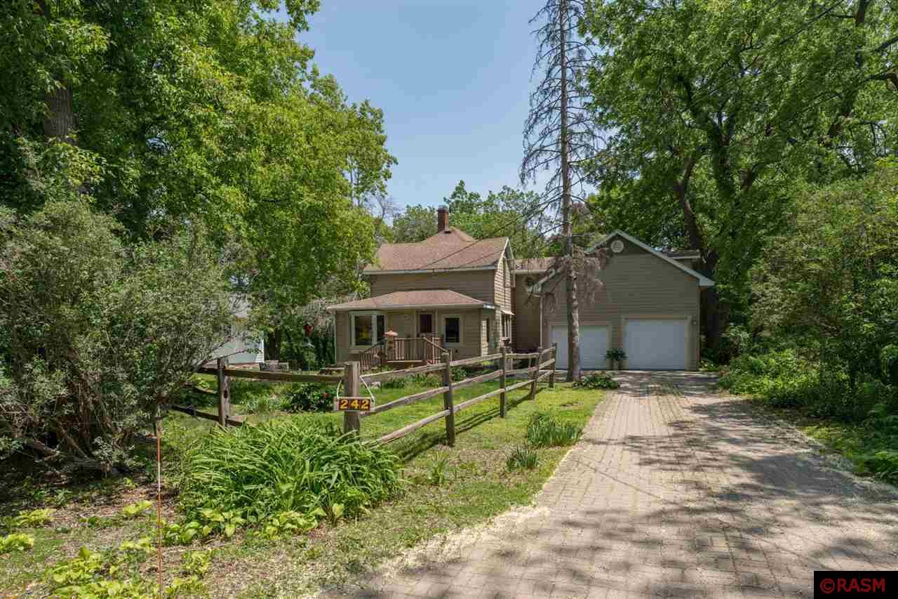 Step into timeless charm with this well maintained 1880s farmhouse, nestled in Mankato's desirable hilltop neighborhood. This unique 3-bedroom, 2-bath home blends historic character with modern convenience, offering a lifestyle that’s both cozy and functional.  The main floor features beautiful hardwood floors that carry throughout a warm and inviting layout. An updated, eat-in kitchen blends charm with modern function, while a formal dining room offers the perfect space for hosting. The cozy living room includes a fireplace for added comfort and character, and a main-floor bathroom adds convenience. Step out from the main living space to the large deck—ideal for relaxing or entertaining—overlooking a peaceful backyard and ravine setting. A spacious attached 2-stall garage—rare for a home of this era—include versatile bonus room above that can serve as a luxurious oversized primary suite, home gym, second living room, or creative retreat. Inside, classic farmhouse details shine, while updates throughout make for easy living.