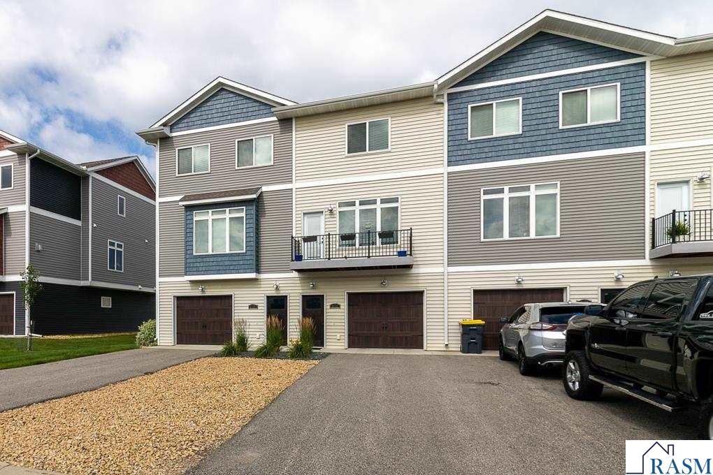 Welcome to this beautifully maintained 3-bedroom, 3-bathroom townhome offering simple living in a bright and airy space. The first level features one bedroom, a full bathroom, a kitchen with a center island, and a spacious living room filled with natural light—perfect for relaxing or entertaining. A private balcony extends your living space outdoors. On the upper level, you'll find two separate bedrooms, each with an ensuite bath—ideal for privacy and convenience. This level also includes a conveniently located laundry area for added ease. A 2-car tandem garage provides generous parking and storage, with additional off-street parking conveniently located across the road. This property also holds a current rental license and is grandfathered to allow up to five unrelated occupants—an excellent opportunity for flexible living arrangements or future investment potential. Situated in a great location within a well-kept community and close to local amenities, this home blends function, comfort, and modern style. Schedule your showing today and experience all this move-in-ready townhome has to offer!