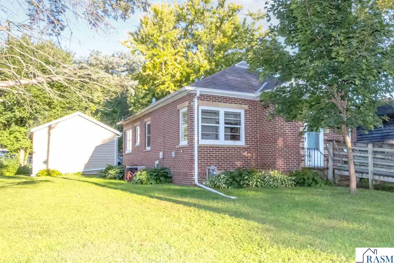 Charming 1.5-story brick home with a handicap-accessible entry and bath, plus laundry available on both the main and lower levels for extra convenience. The bright living room and eat-in kitchen, accented with stone walls, create a warm and welcoming feel. Spacious bedrooms and beautiful hardwood floors add to the home’s character. Step outside to enjoy the nicely landscaped yard, perfect for curb appeal and outdoor gatherings. The three-season screen porch with slate flooring is an ideal spot to relax. A newer, oversized single garage with high ceilings and plenty of off-street parking adds great functionality. With a walk-up attic and unfinished basement, there’s lots of space to grow. Located close to Land of Memories Park, this home offers wonderful potential with just a touch of TLC.