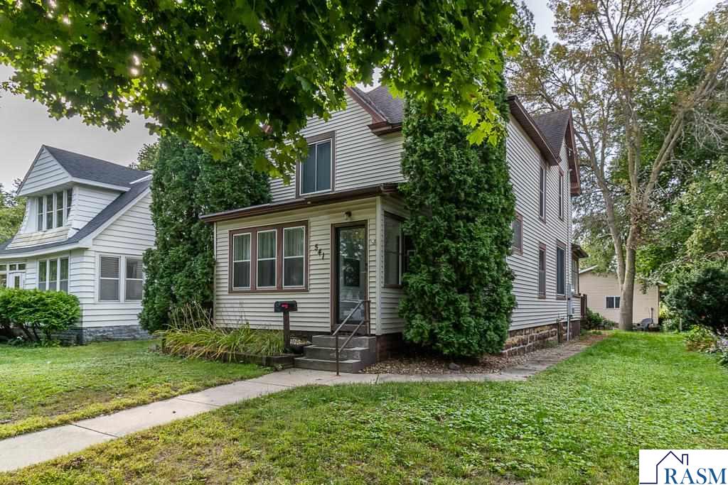 This 3-bedroom, 2-bath, 3-stall garage home is located in the desirable Lower North neighborhood of North Mankato. This turn-of-the-century property has been thoughtfully updated while maintaining much of its original character and historic features. The main level offers a spacious living room with a shiplap accent wall, a bright sunroom, and a large dining room with white beadboard wainscoting and wood plank flooring that continues into the kitchen with a butcher block island and stainless steel appliances. Off the kitchen are a full bath, enclosed back entry/mudroom, and access to the basement, which features a recently remodeled family room, laundry area, and half bath. Upstairs are three bedrooms, including a large primary bedroom with a walk-in closet. The property also includes a spacious backyard with a fire pit area and deck, and a large 3-stall garage/shop that is insulated and heated, with ceiling fans, a workbench, and an oversized concrete slab for additional parking. Additional recent updates include fresh interior paint, new window treatments throughout, and new flooring in the front porch.