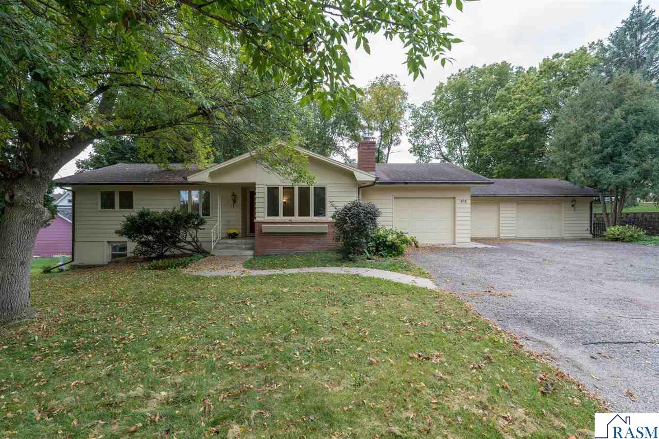 Welcome to this spacious 3-bedroom, 2-bath rambler situated on a beautifully landscaped corner lot in St. Peter. This home features a 3-stall heated attached garage, fenced backyard, and thoughtful updates throughout. The main floor showcases a welcoming living area with a gas fireplace, a formal dining room, kitchen and informal dining space. Hardwood floors, 6-panel doors, and a main floor den/office with its own gas fireplace add to the home’s character. The primary bedroom includes a dressing room with laundry and a convenient walk-through full bath. The finished lower level has natural light from daylight windows and provides even more living space with a large rec room, two additional bedrooms, a 3/4 bath, and a second laundry hookup. Additional highlights include efficient hot water zoned heating, blown-in attic insulation (2019), and gutter guards (2020). This well cared for home combines classic style with modern efficiency—ready to welcome its next owner!
