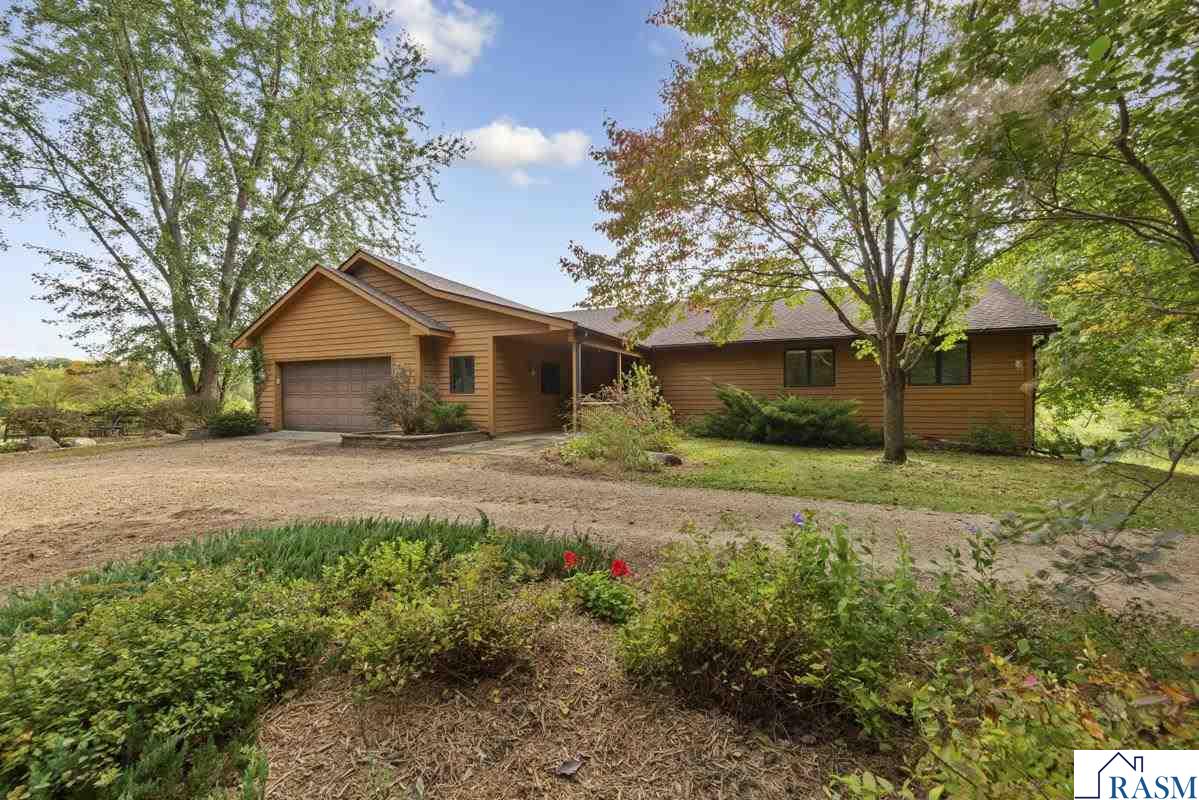 Country Estate on 37+ Acres. Experience the serenity of wide-open spaces on this 37+ acre property with a wraparound deck overlooking acres of fields, rolling hills and pasture ground. It’s more than just land—it’s a retreat, a reset, plenty of space for loved ones to gather. It gives privacy, it isn’t just place isn’t a place to live, it's your own little piece of paradise. The entryway to the home opens to a bright, sunlit interior. From the oversized garage, featuring in-floor heat, is a large mudroom and powder room, ideal for cleaning up after a day outdoors. Steps inside the Living Room with in-floor heat, soaring wall to wall windows and cozy Fireplace create the ultimate lodge style gathering space. The Kitchen is designed for both beauty and function, featuring quartz countertops, a spacious island, a built-in buffet, plenty of custom cabinet space to keep everything organized, while the open layout flows seamlessly into the dining room and living room. The main level offers two spacious bedrooms, a full bathroom, and a versatile private office or den.  Lower level: In addition to the third bedroom, you'll love the newly updated flooring, additional gas stove, look out windows and third bathroom- perfect for a cozy guest space or recreational area.  Exterior and Land: Pole shed and partial fencing- ideal for horses, hobby farming or heavy equipment storage. 37+ Acres of open land and mature trees perfect for exploring, livestock, hunting or simply soaking in the view. This home offers the rare combination of rustic outdoor charm and modern upgrades, giving you the perfect Yellowstone-inspired escape without leaving home. The township is well-connected by roads; Interstate 35 and State Highway 19 run through it for easy commuting.
