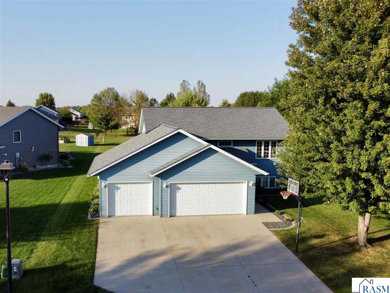 Located in the Country Club Estates on Mankato’s Hilltop, this meticulously maintained 4 bedroom 2 bath home offers a functional layout and plenty of additional spaces. As you approach the front door, the hardwired walkway lights lead you past manicured, low maintenance landscaping. Entering the home, the foyer is spacious and connects directly to the heated 3-stall garage which has a service door to the back and additional storage above. The main level is ideal for entertaining with an open-concept design, showcasing a functional kitchen with stainless appliances, dining room, and living room. This level also includes the primary suite with a walk-in closet, a full bathroom, and additional bedroom/office. The lower level includes a large family room with an electric fireplace, built-in cabinetry and wiring for surround sound, a 3/4 bathroom, two more bedrooms, and a laundry/maintenance room. Outside, enjoy the beautiful deck with attached lanai and steps leading to the massive backyard which provides so much room for activities. Top that off with an outdoor patio, fire pit, and shed built in under the deck for even more storage space. New roof in 2022! Call today to schedule your private showing!